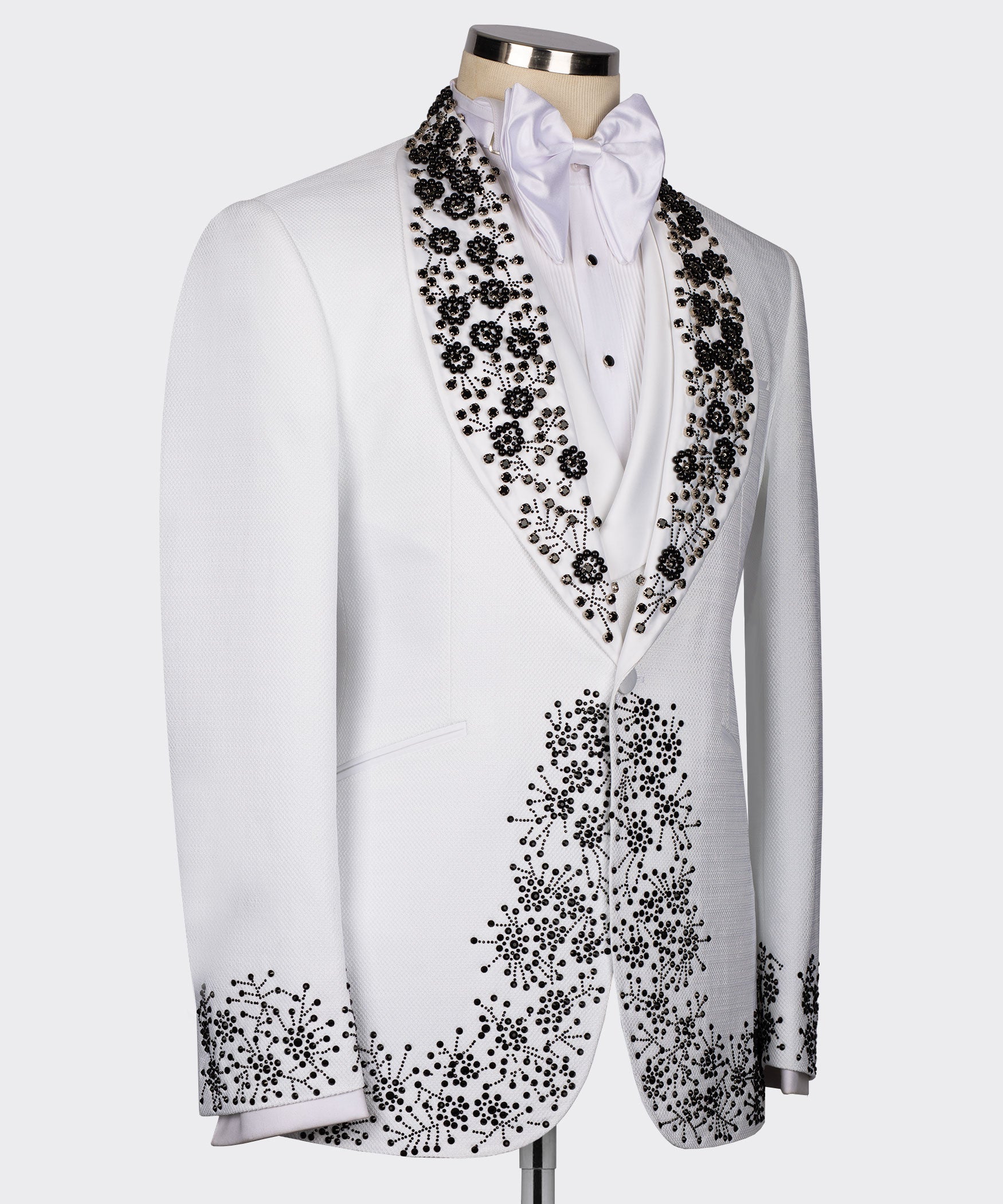 White tuxedo jacket side view with black gemstone embroidery along lapel and cuffs