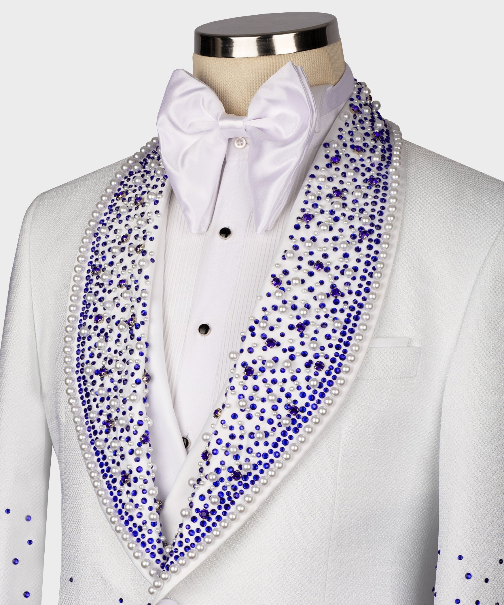 Close-up white tuxedo: blue rhinestone lapels, shirt studs, and bow tie
