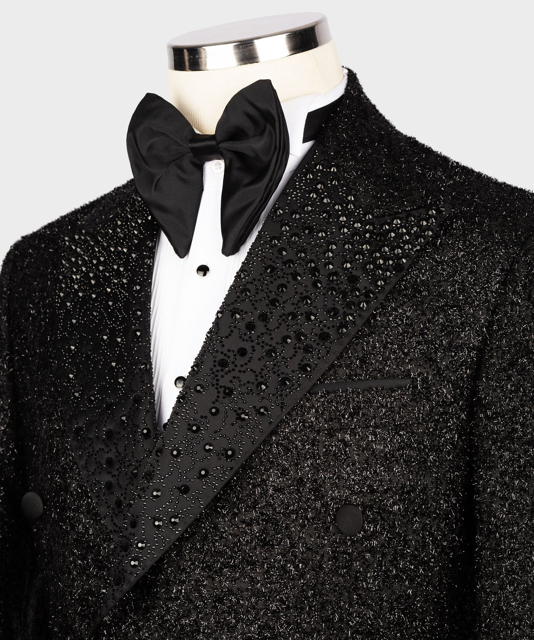 Close-up: black tuxedo lapel with gemstone embroidery and double-breasted buttons