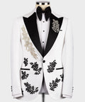 White tuxedo jacket with black lapels, gold floral trim, and black bow tie