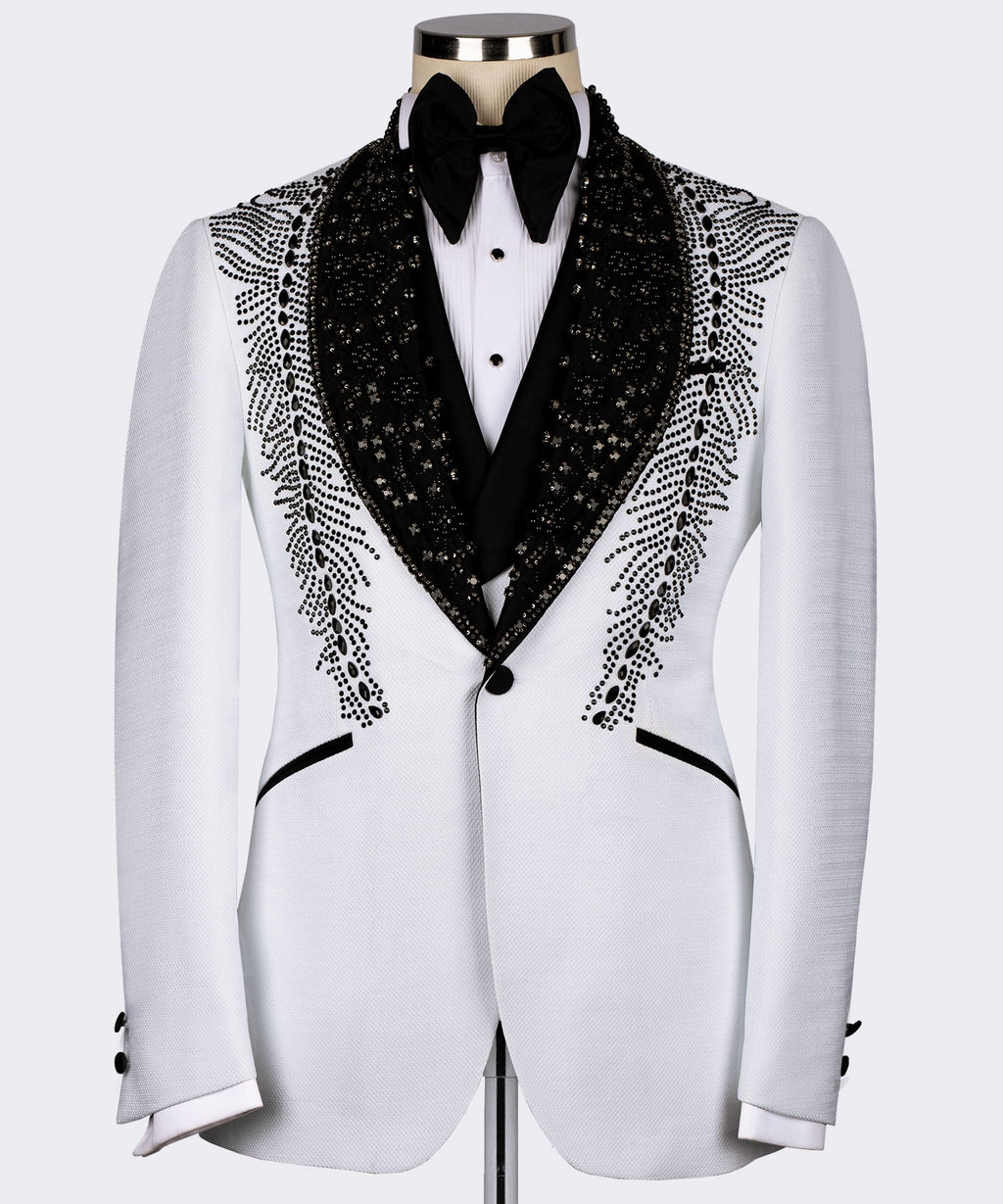 White tuxedo jacket with black embroidered lapels and feather-like stone pattern, bow tie