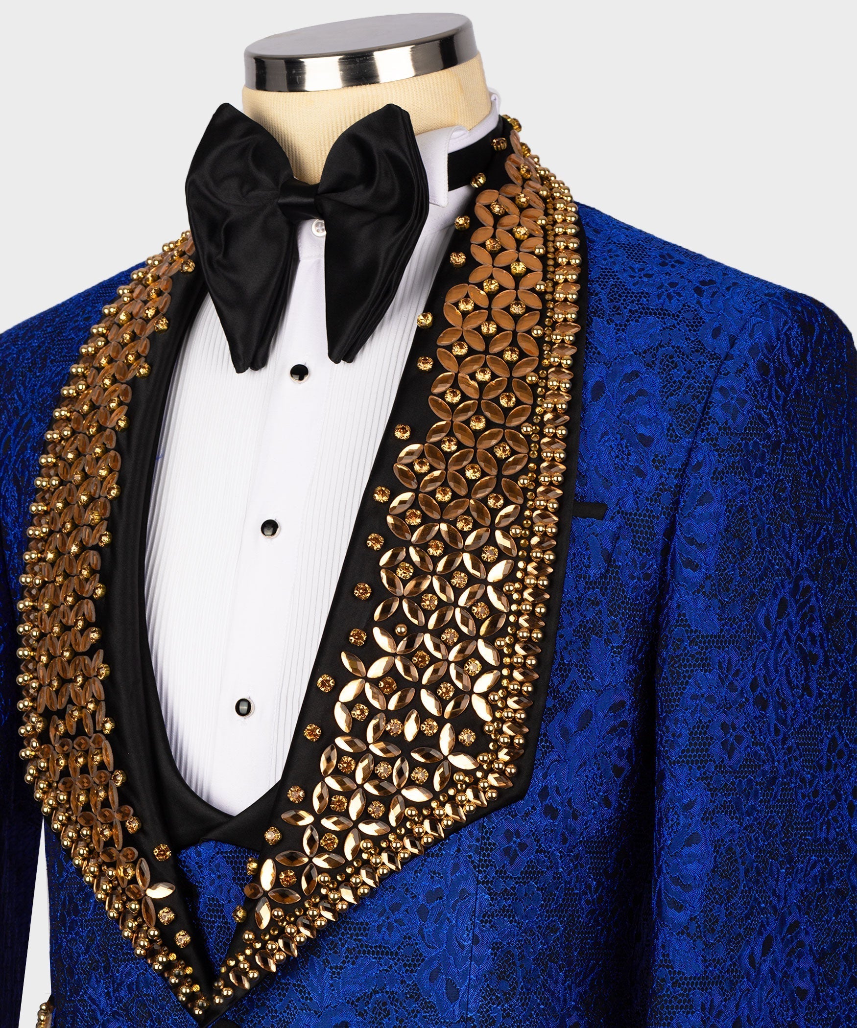 Blue tuxedo lapel close-up with gold gem-stone embroidery and black bow tie