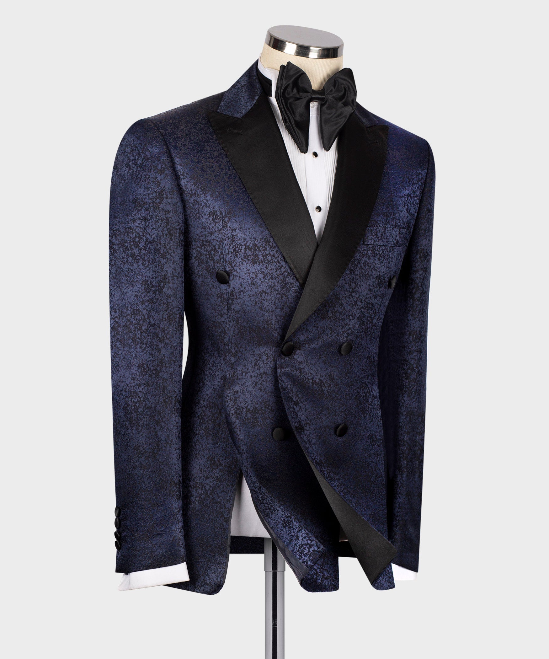 Navy patterned tuxedo jacket with satin lapels, black bow tie, four-button front