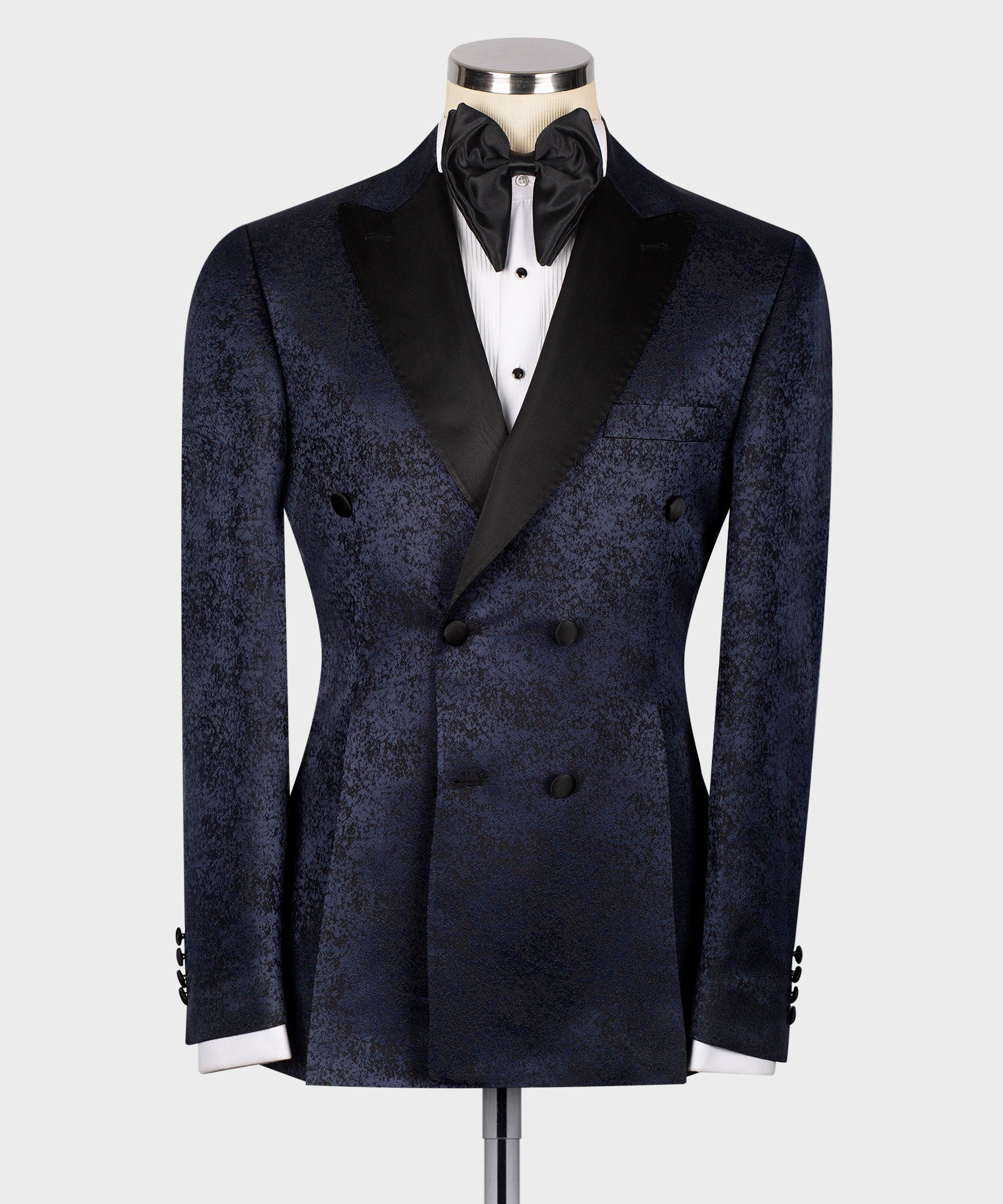 Navy patterned tuxedo jacket with black satin lapels and bow tie, front view on mannequin