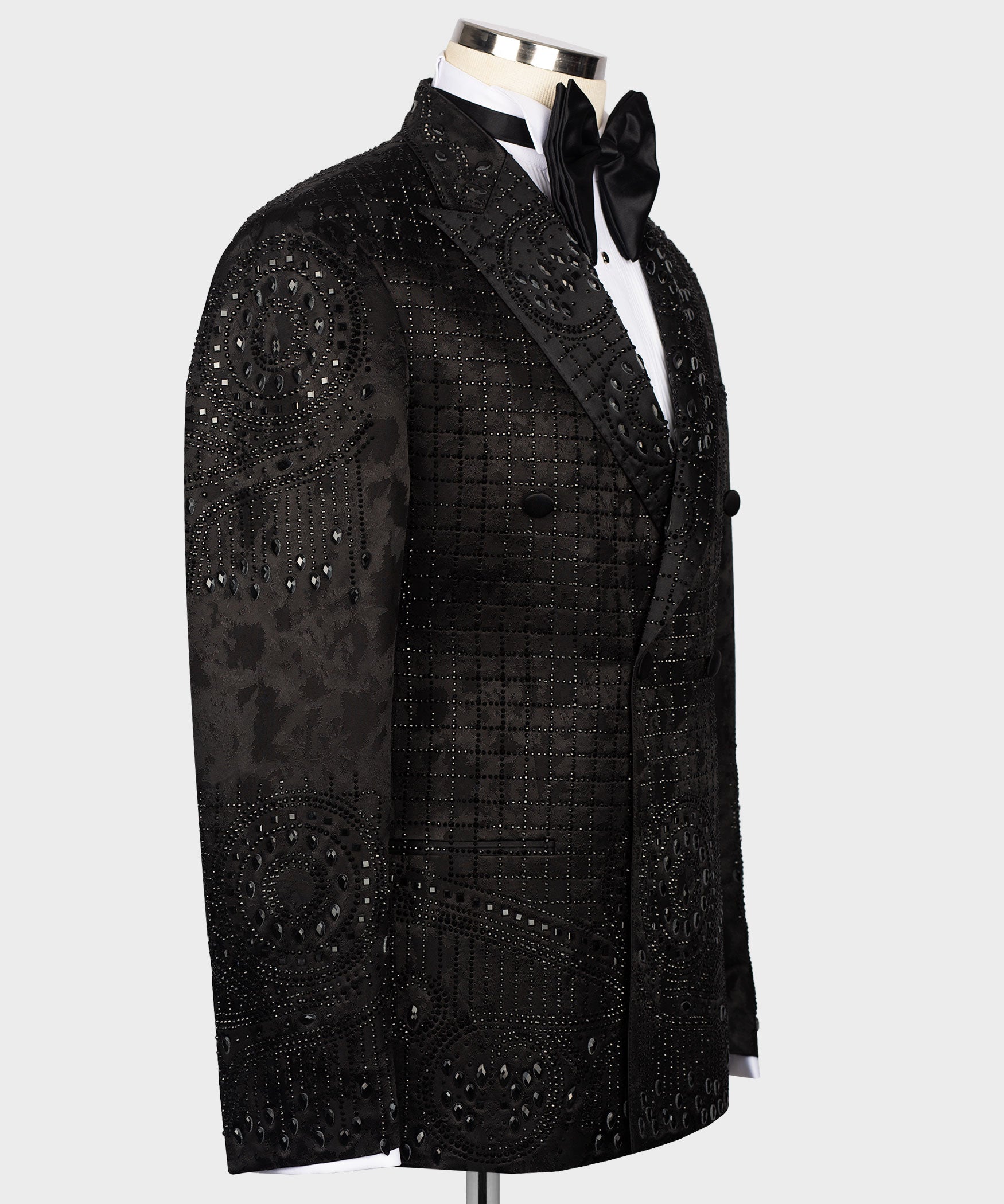 Black tuxedo jacket with embroidered motifs along lapel and chest; bow tie visible