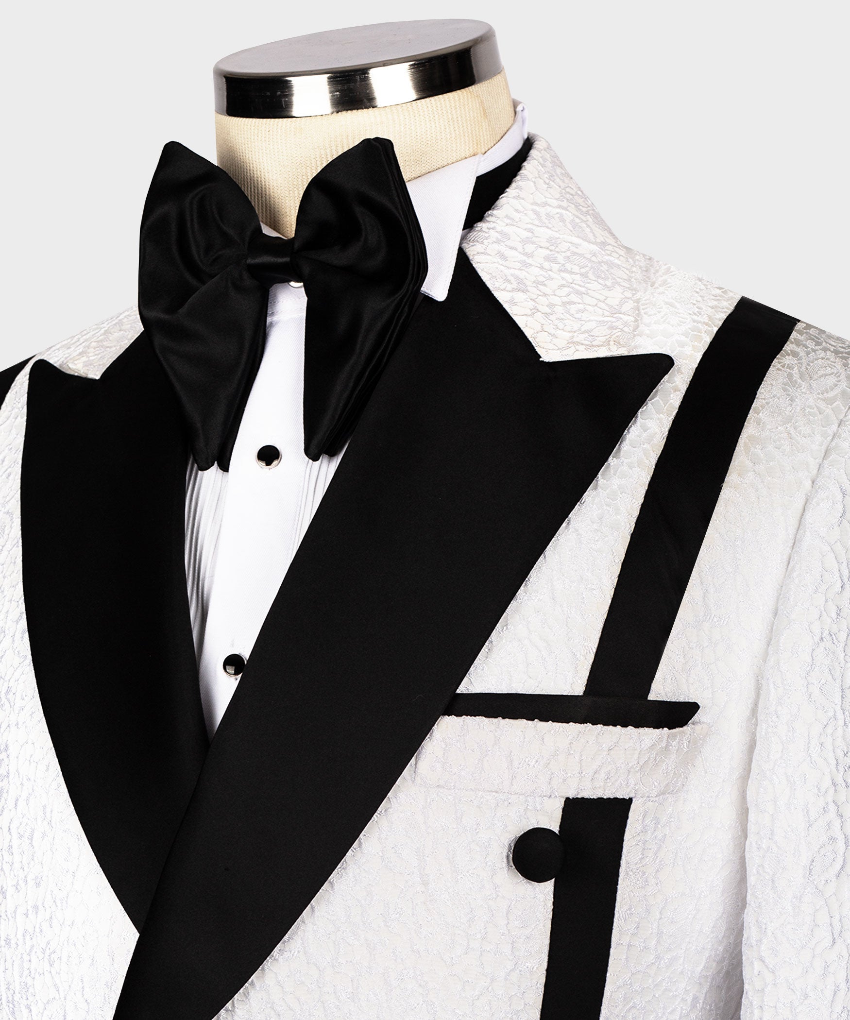 Black bow tie and satin lapels on textured white tuxedo jacket, double-breasted buttons