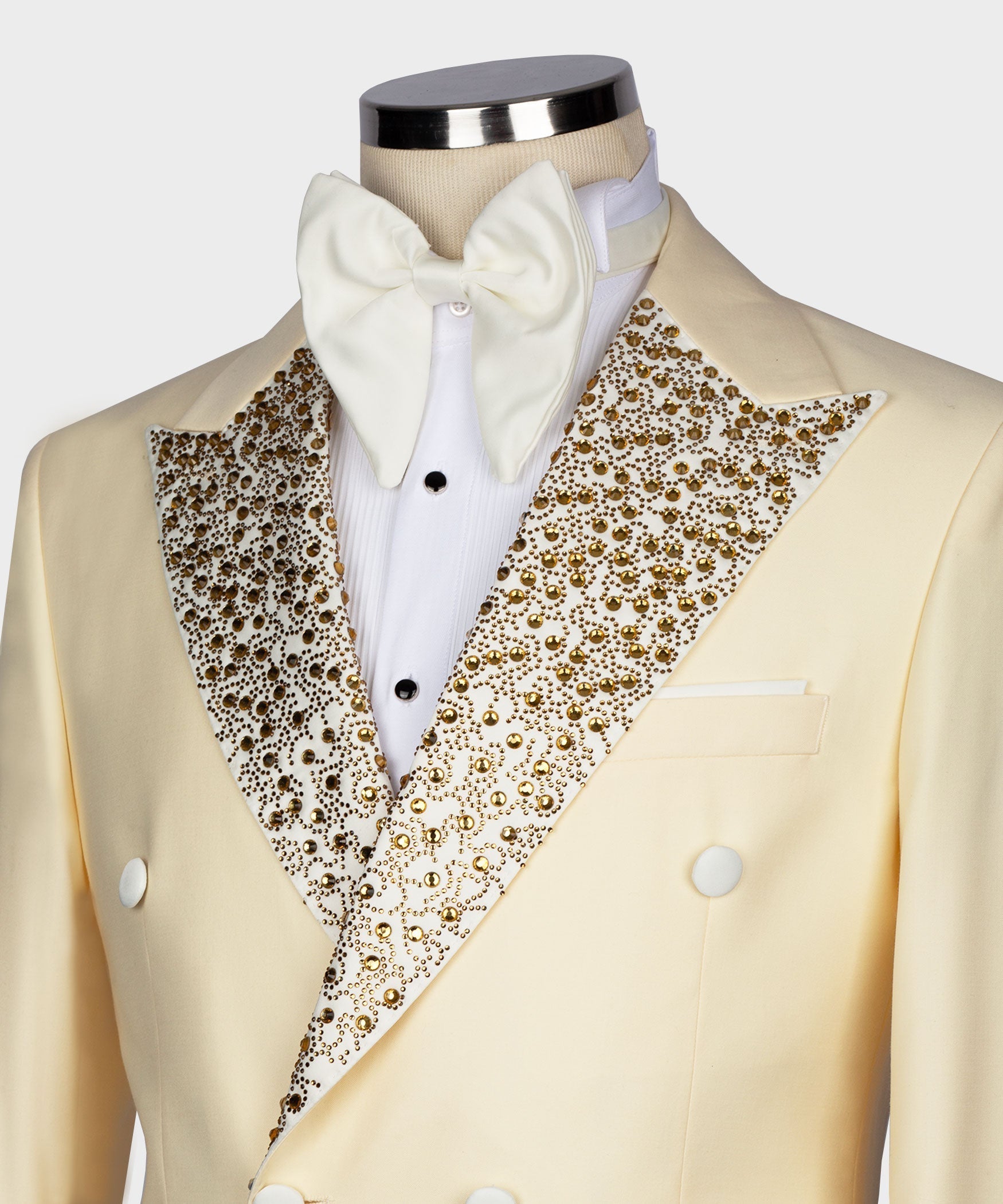 Close-up light yellow tuxedo jacket with gold gemstone-embroidered lapels and bow tie