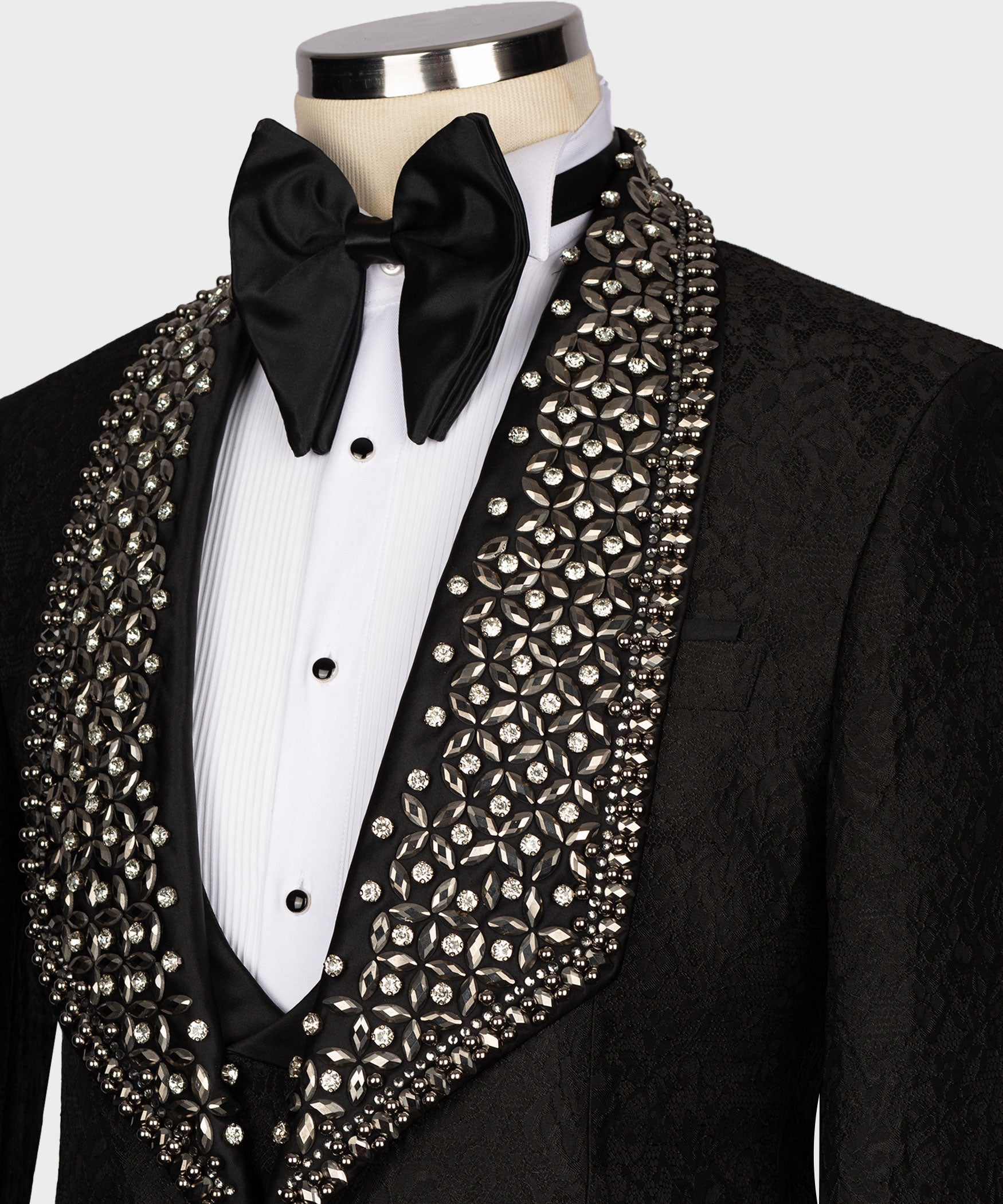 Crystal-studded lapel and front of black tuxedo jacket with satin bow and vest buttons