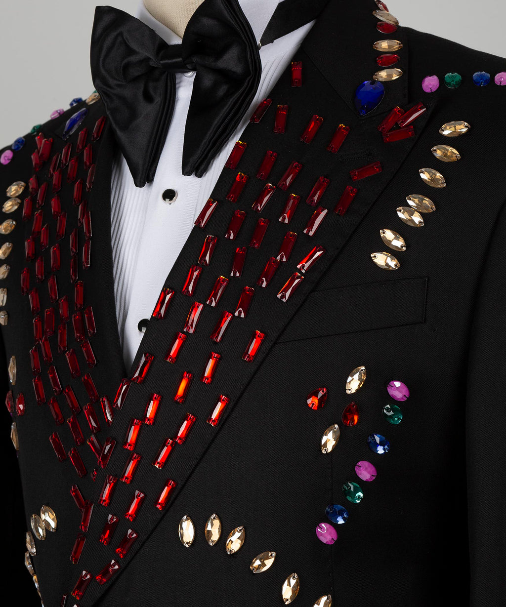 Close-up: black satin bow tie and crystal-studded lapel with red, gold and blue accents
