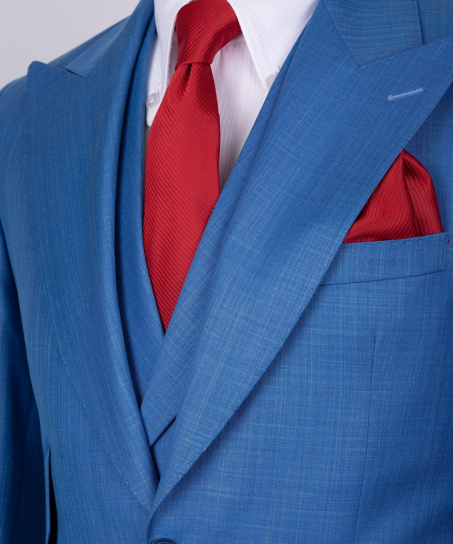 Blue suit lapels with red tie and red pocket square over a white striped shirt