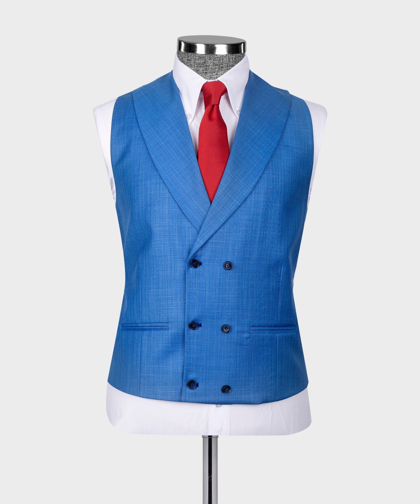 Blue vest with dark buttons over a white shirt and red tie