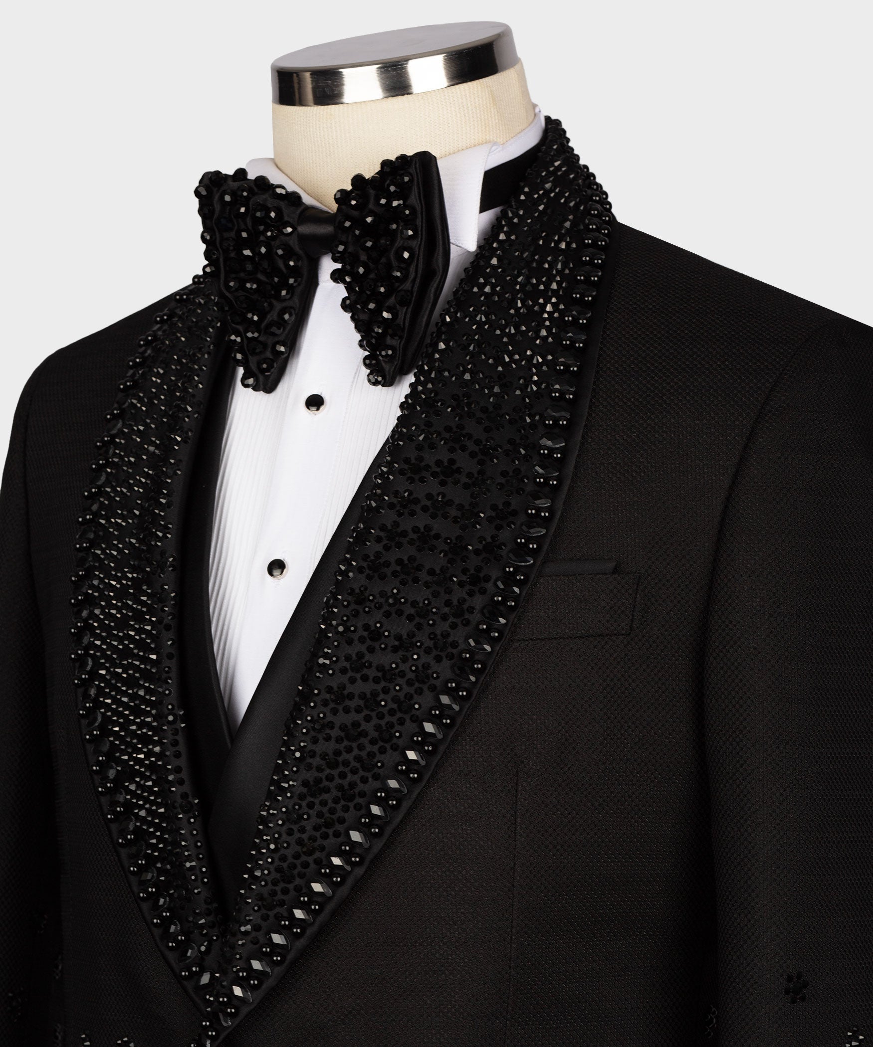 Black tuxedo jacket lapel close-up with jeweled bow tie and breast pocket