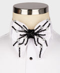 Koss Atelier white silk bow tie featuring intricate black beadwork and silver floral embellishments on a dress shirt.