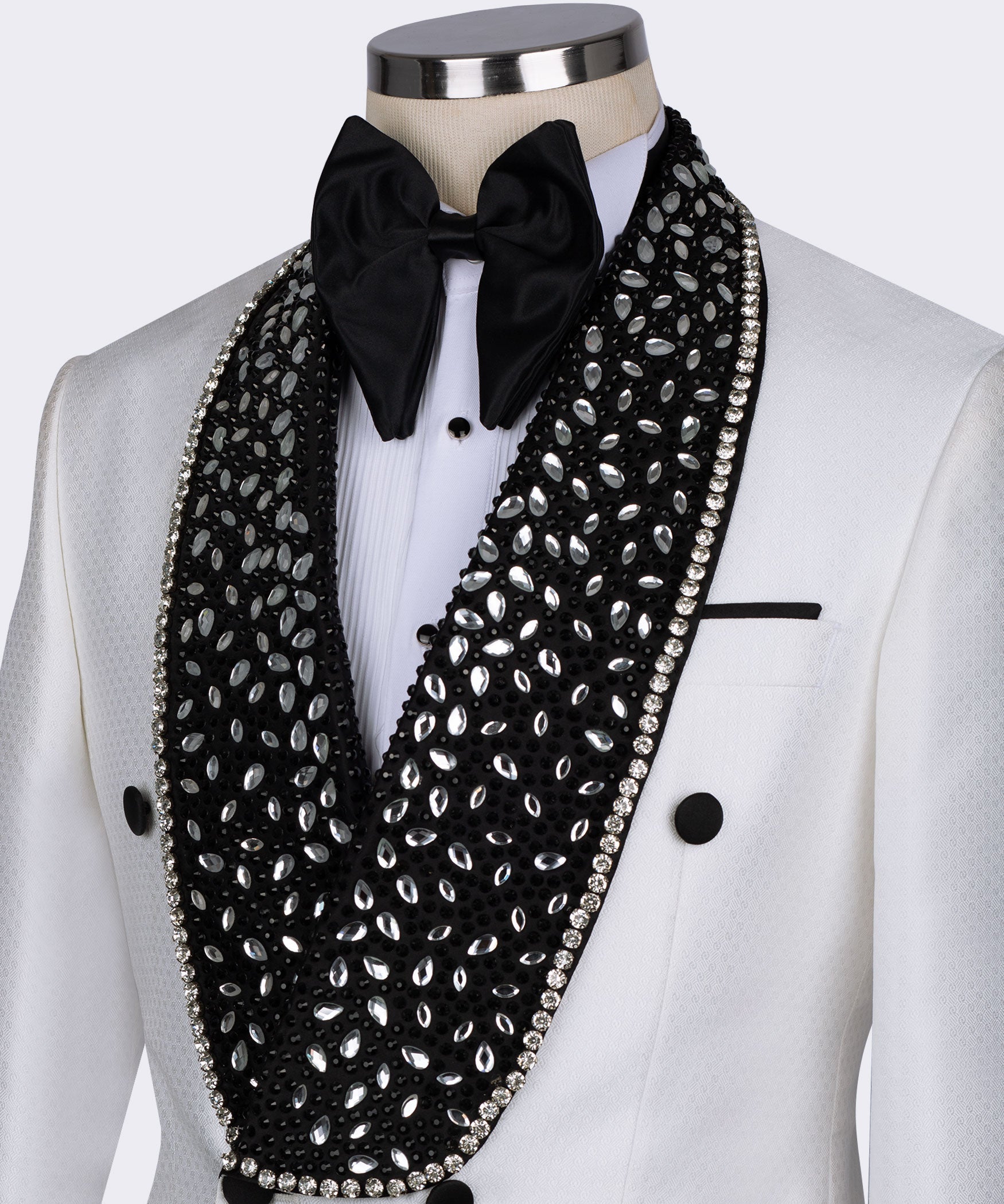 Close-up: white tuxedo collar with black gem lapel, rhinestone trim, and black bow tie