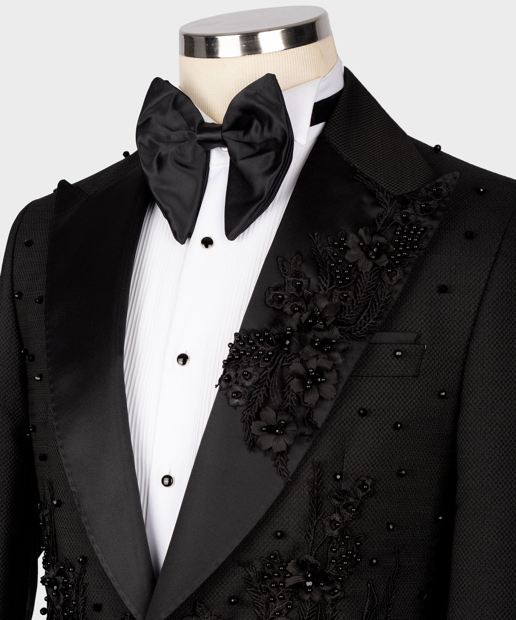 Black tuxedo lapels with floral appliqué, satin bow tie, and white shirt front