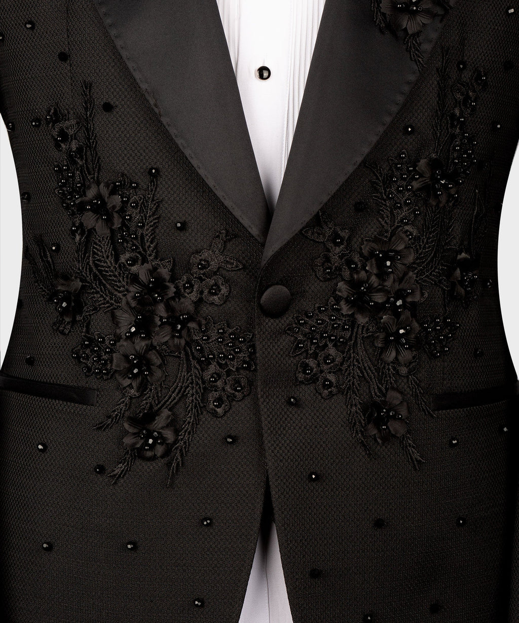 Close-up of black tuxedo jacket front with floral embroidery on satin lapels