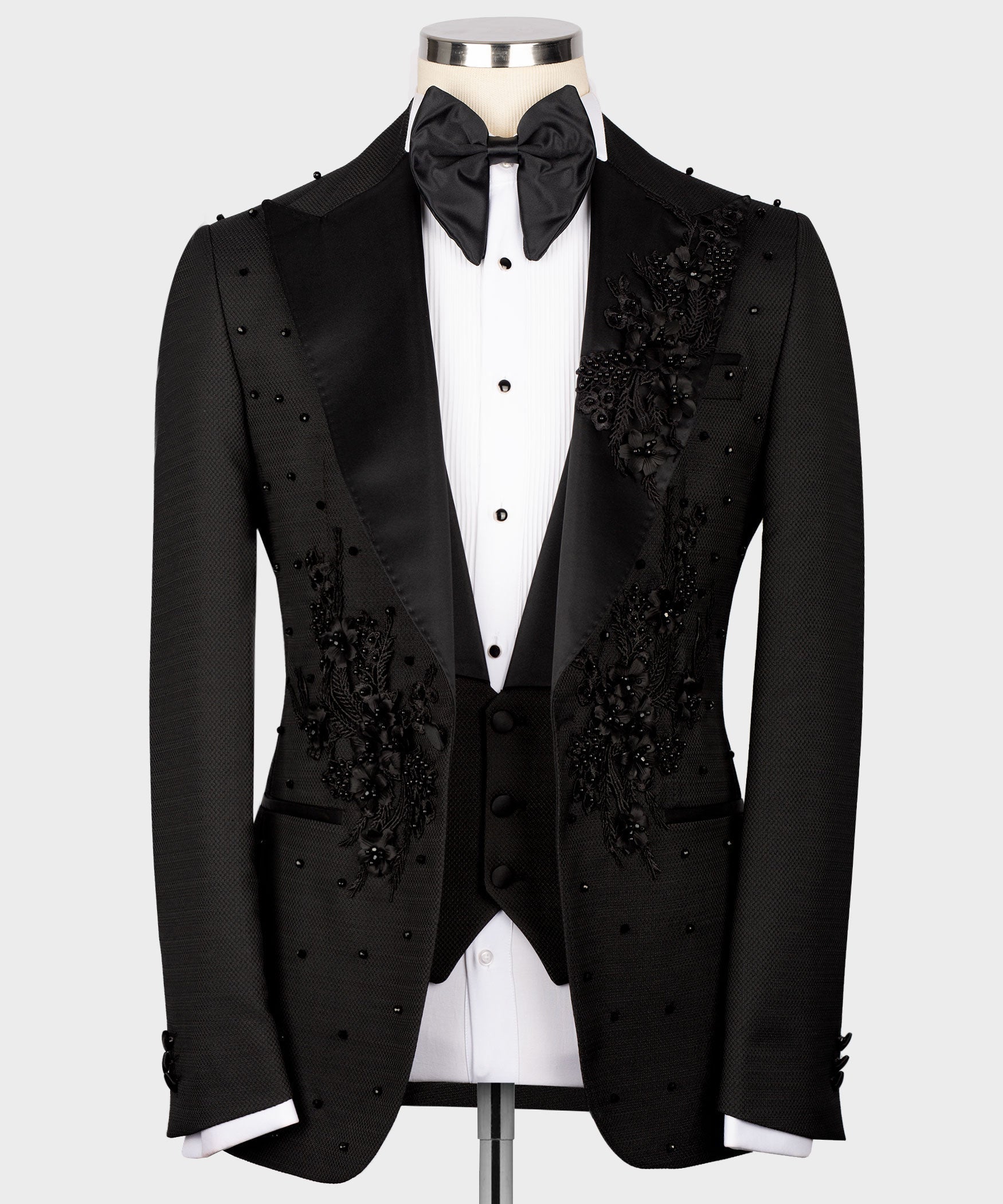 Black tuxedo jacket with floral embroidery, satin lapels, and matching bow tie