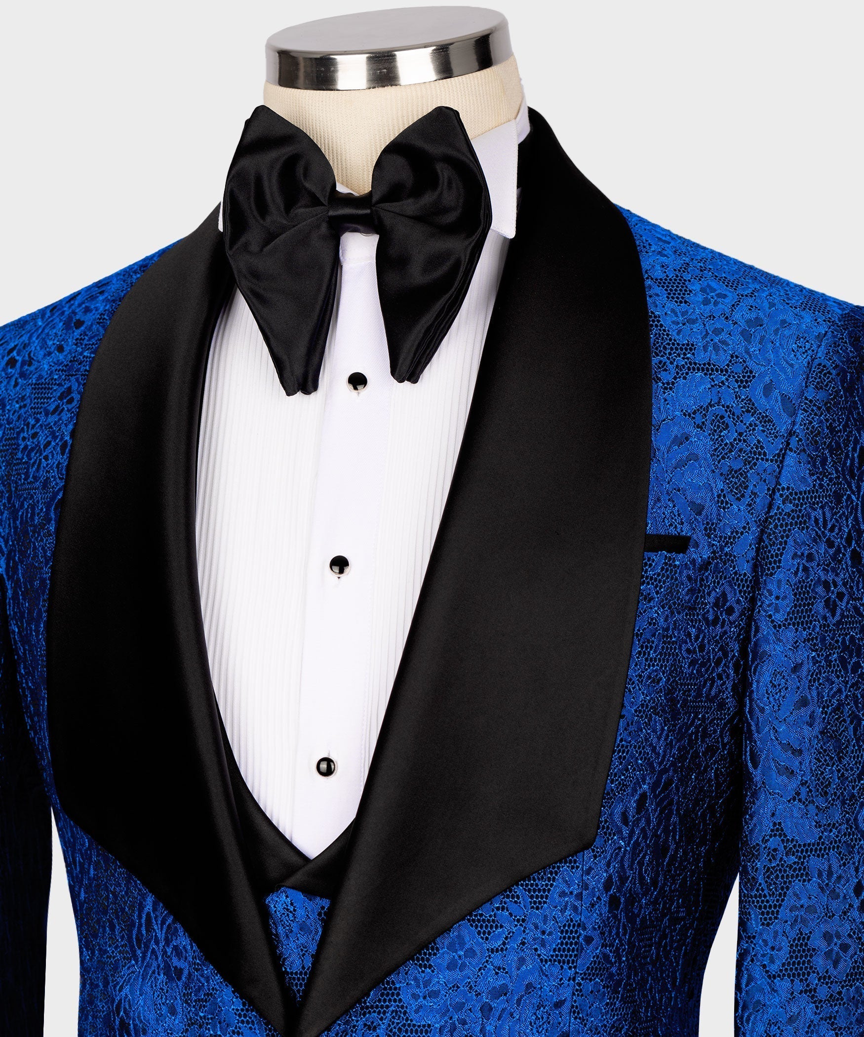 Close view: black satin bow tie and lapels over white shirt front with blue embossed vest