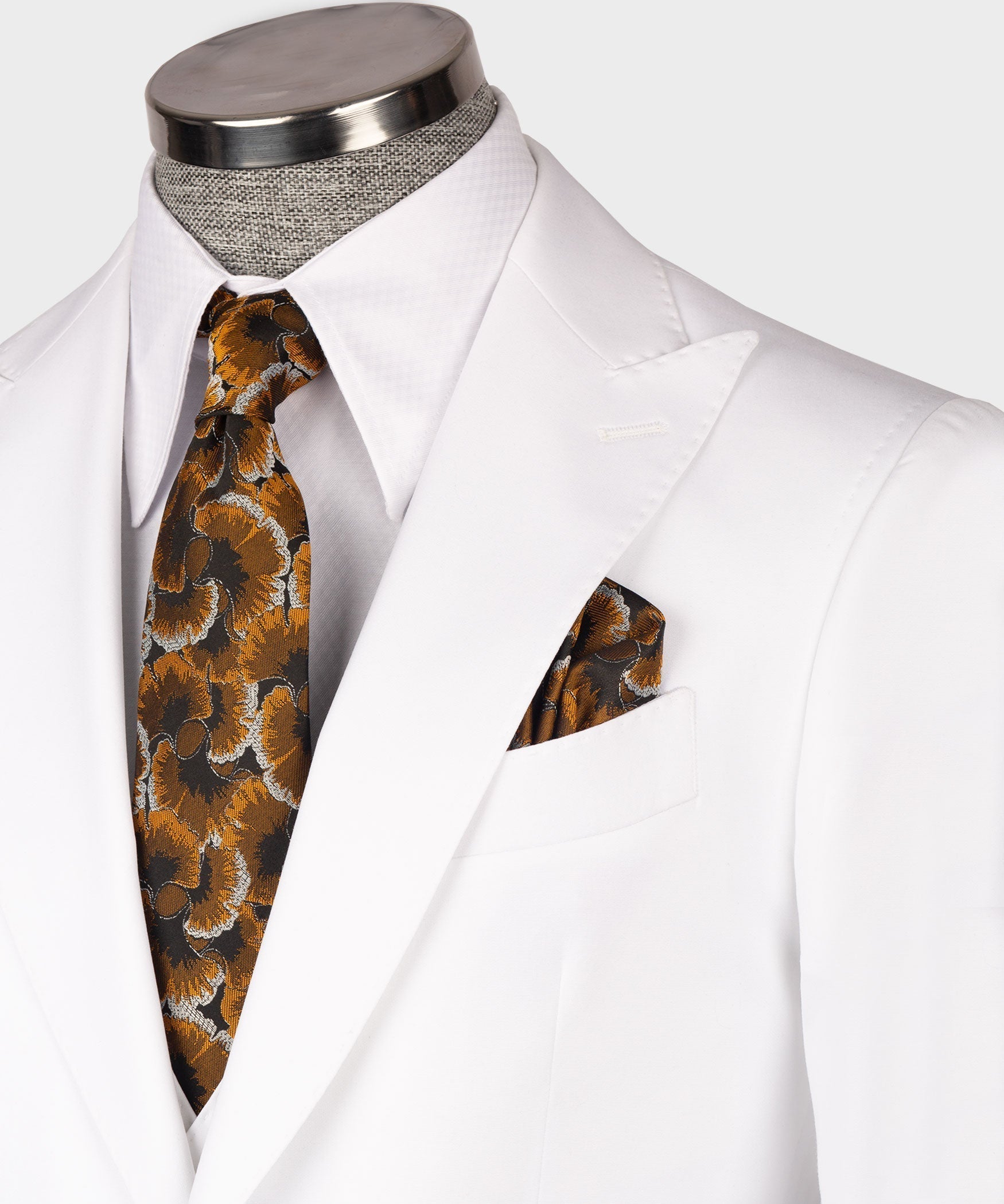 Close-up of white waistcoat lapels with patterned necktie and matching pocket square