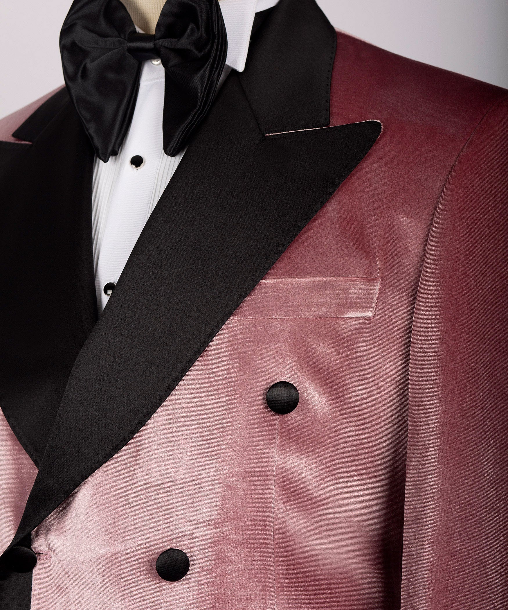 Close-up of pink velvet tuxedo lapel and double-breasted buttons with black satin trim