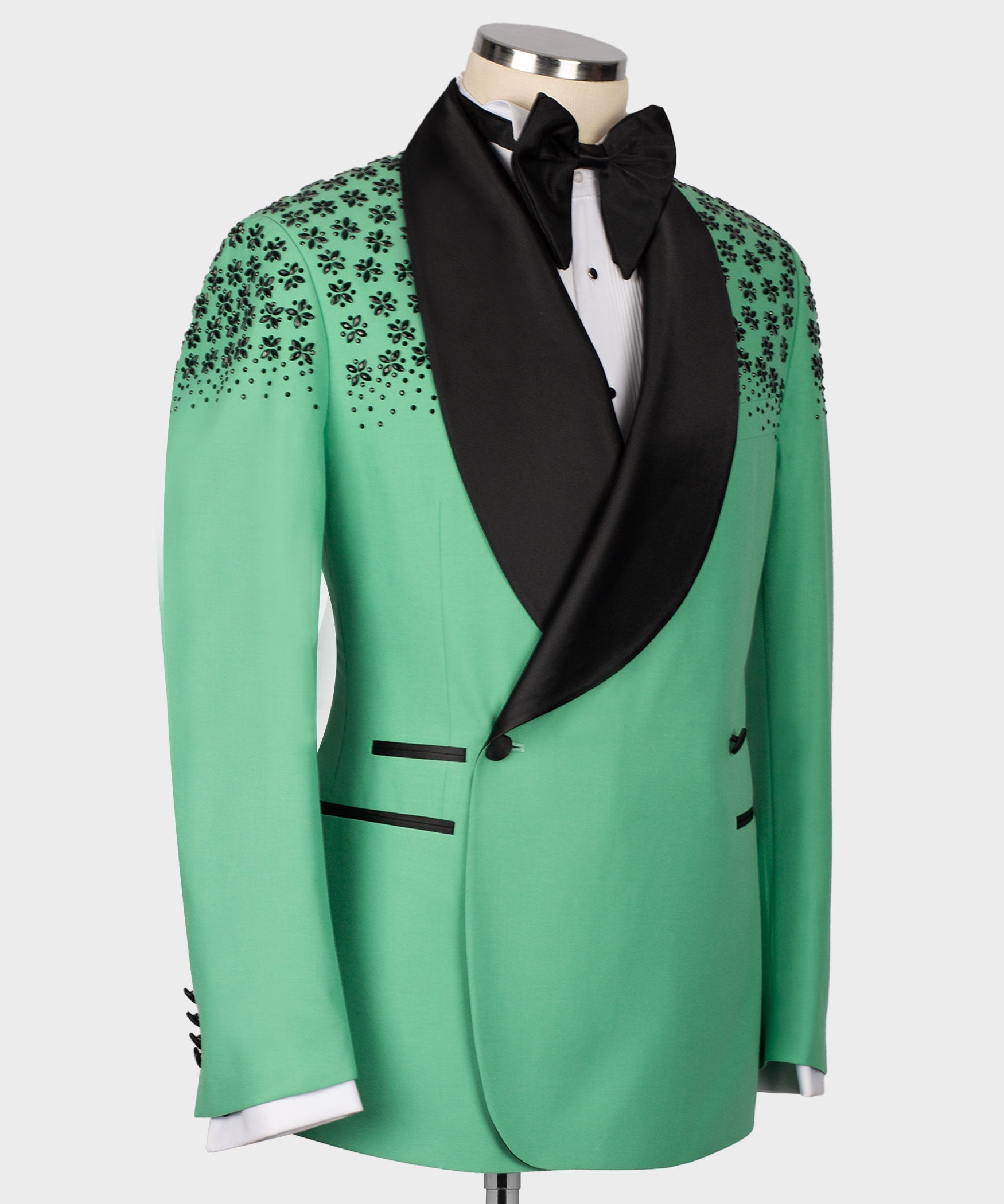 Light green tuxedo jacket with black shawl lapel and stone-embroidered floral pattern on shoulders.