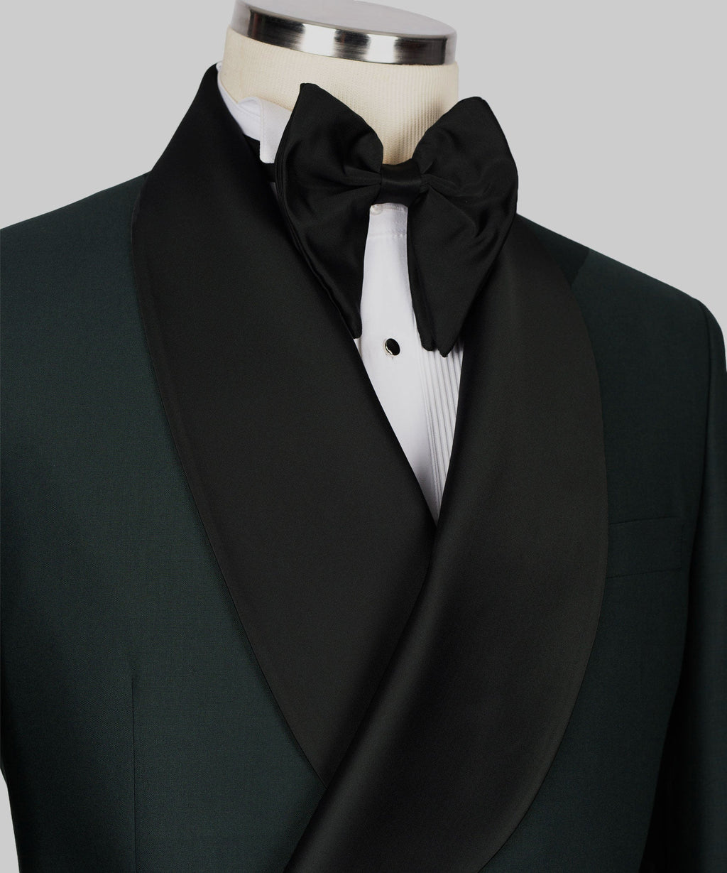 Close-up of black satin bow tie and shawl lapel on green tuxedo jacket