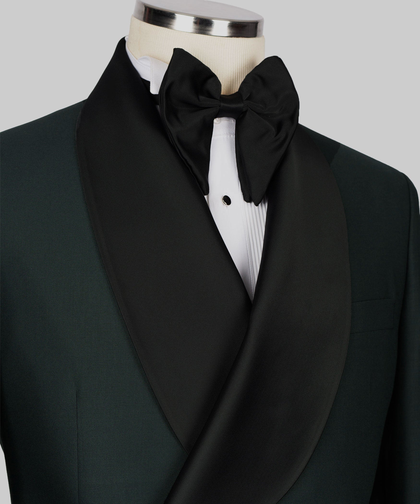 Close-up of black satin bow tie and shawl lapel on green tuxedo jacket