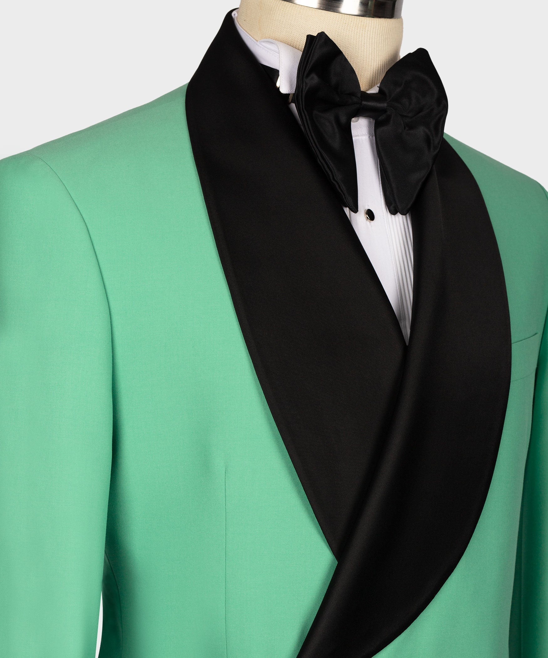Close-up green tuxedo with black shawl lapel and bow tie over white shirt