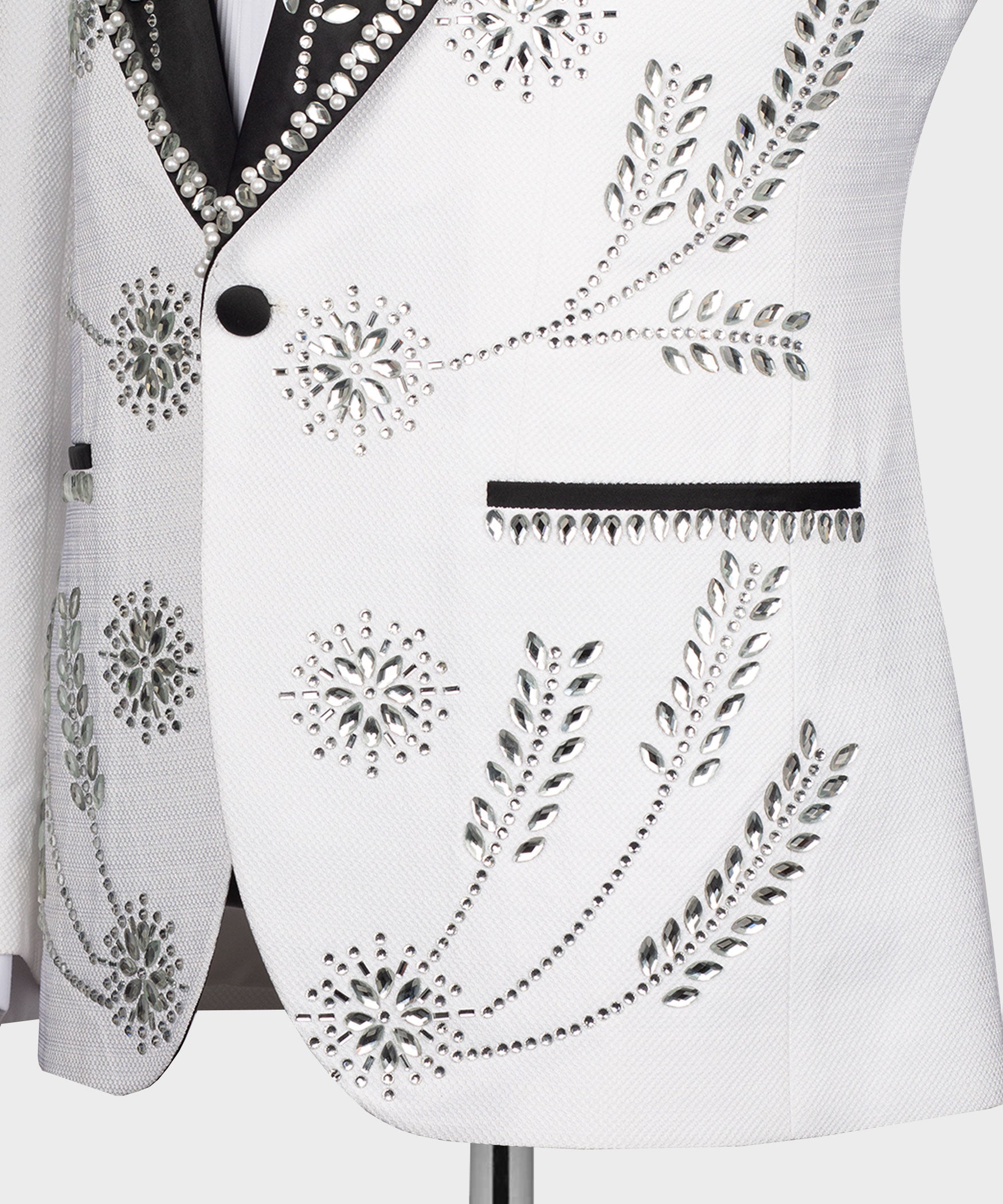 Close-up of white tuxedo jacket front with rhinestone buttons and beaded design panel