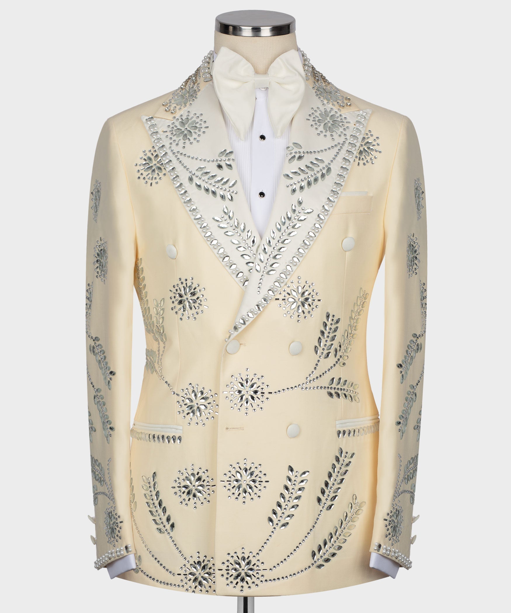 Cream tuxedo jacket with gemstone beaded embroidery, white bow tie, and satin lapels