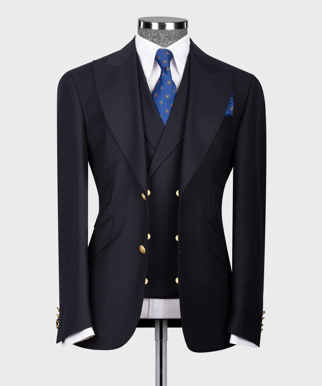 Dark navy vest suit with gold buttons, notch lapels, patterned blue tie and pocket square