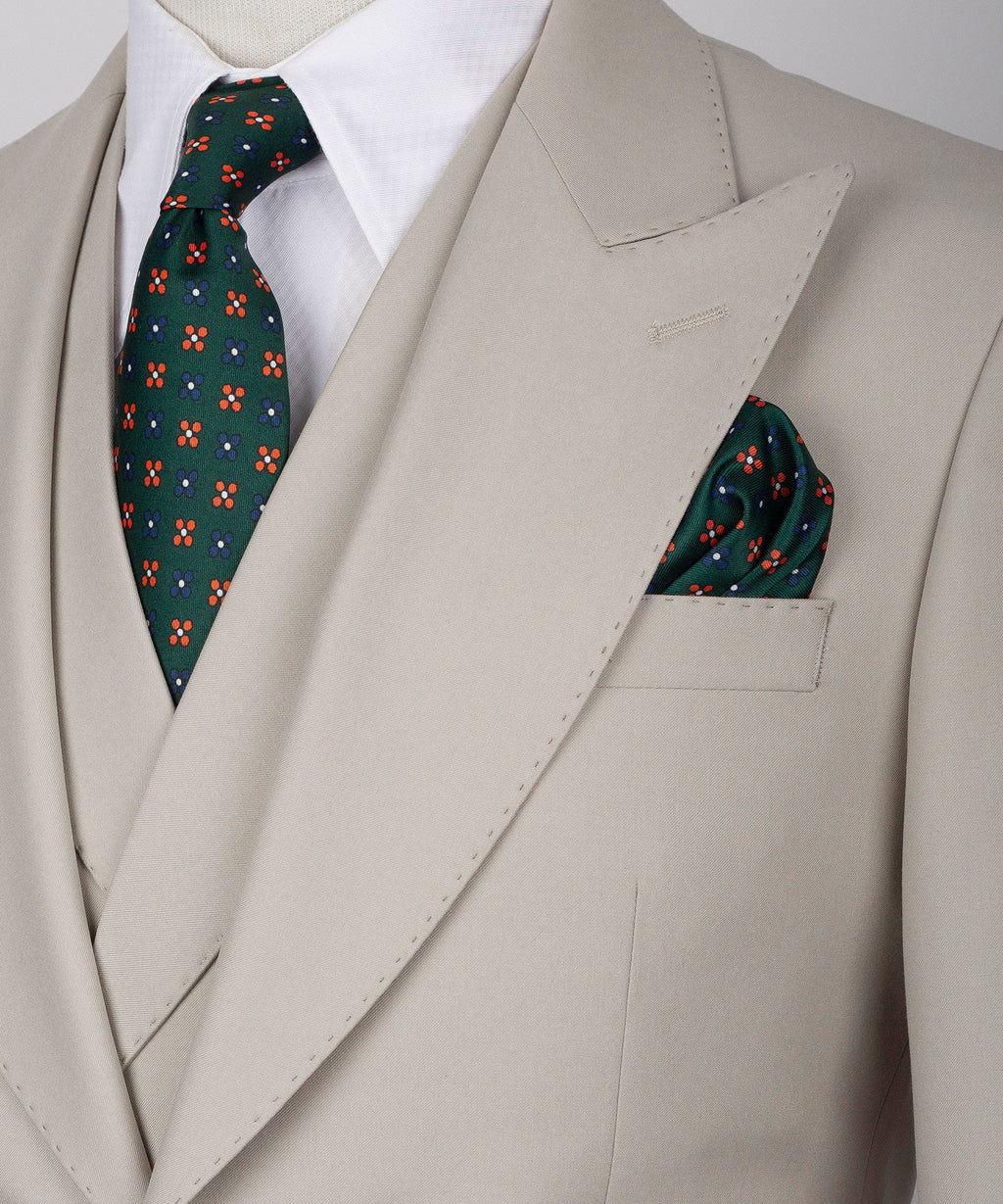 Close-up light taupe lapel with patterned tie and folded pocket square