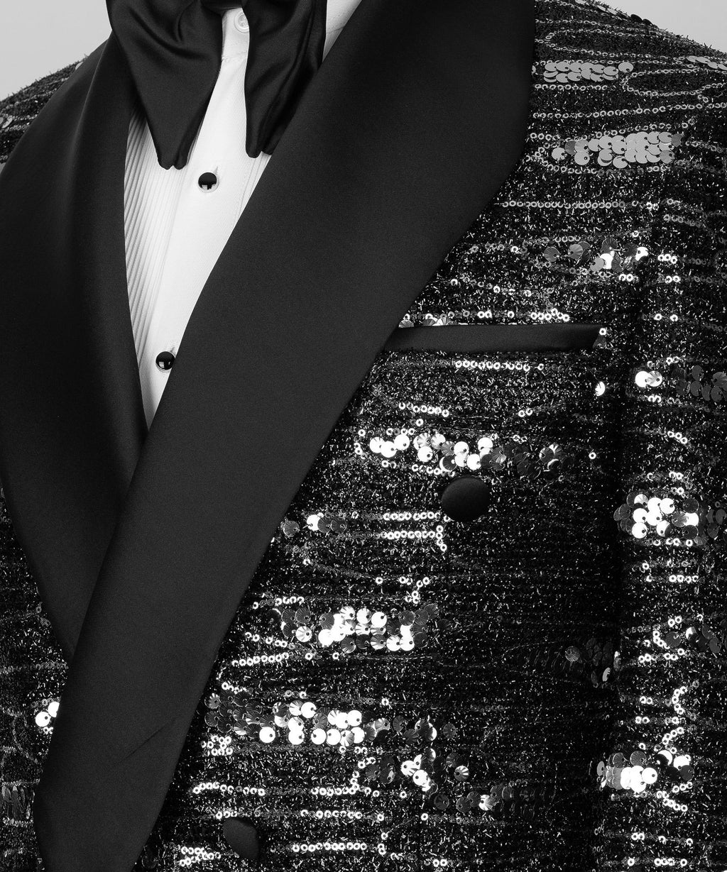 Close-up of black satin shawl lapel and sequined fabric with double-breasted buttons
