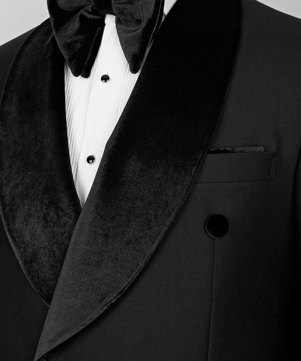 Velvet lapel close-up with dark buttons, welt pocket, and white striped dress shirt