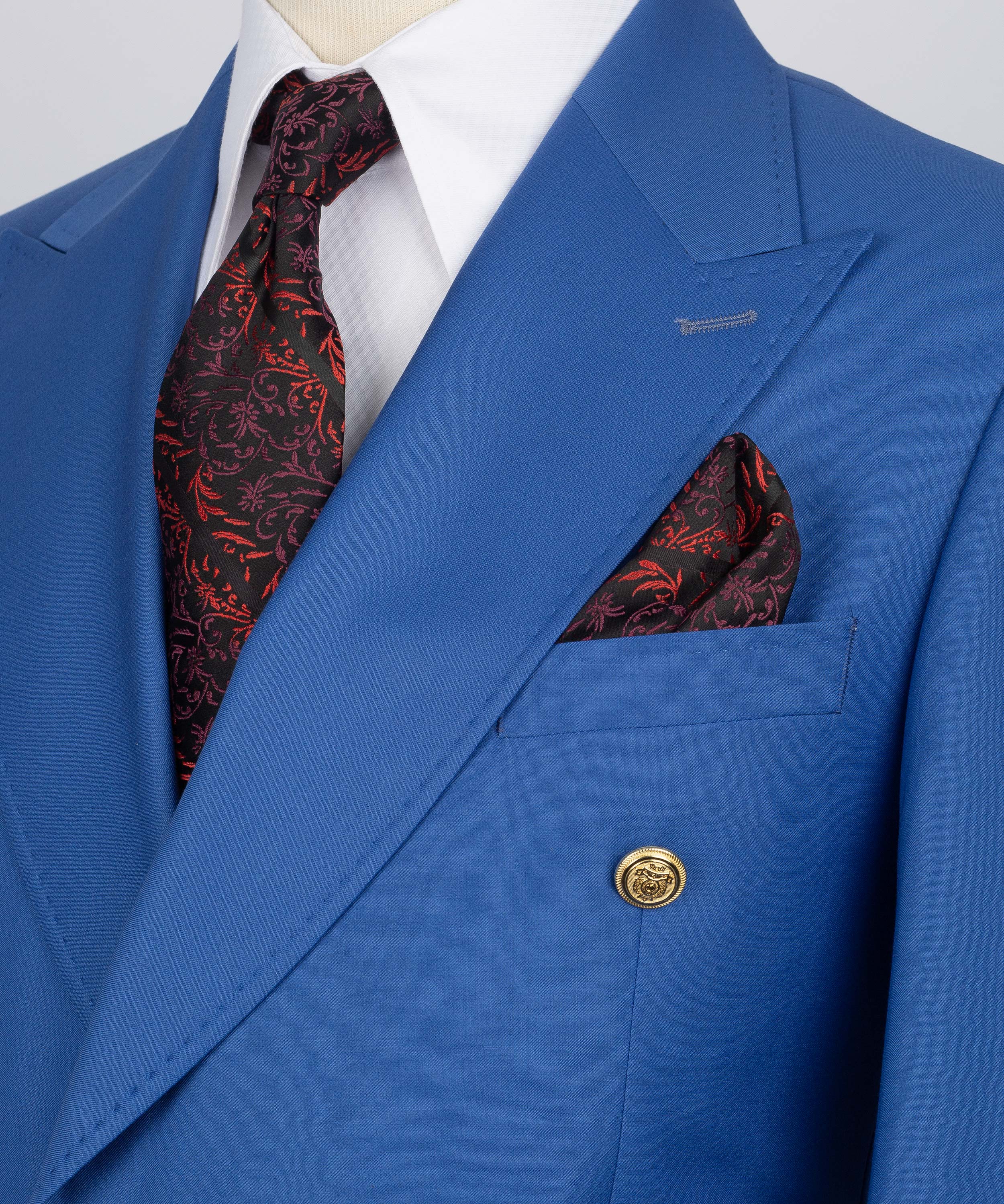 Close-up of blue lapel, gold button, and red patterned pocket square
