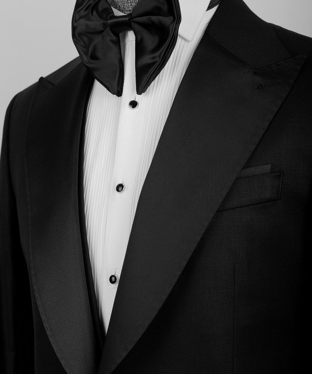Black tuxedo lapel with satin bow tie over white striped waistcoat