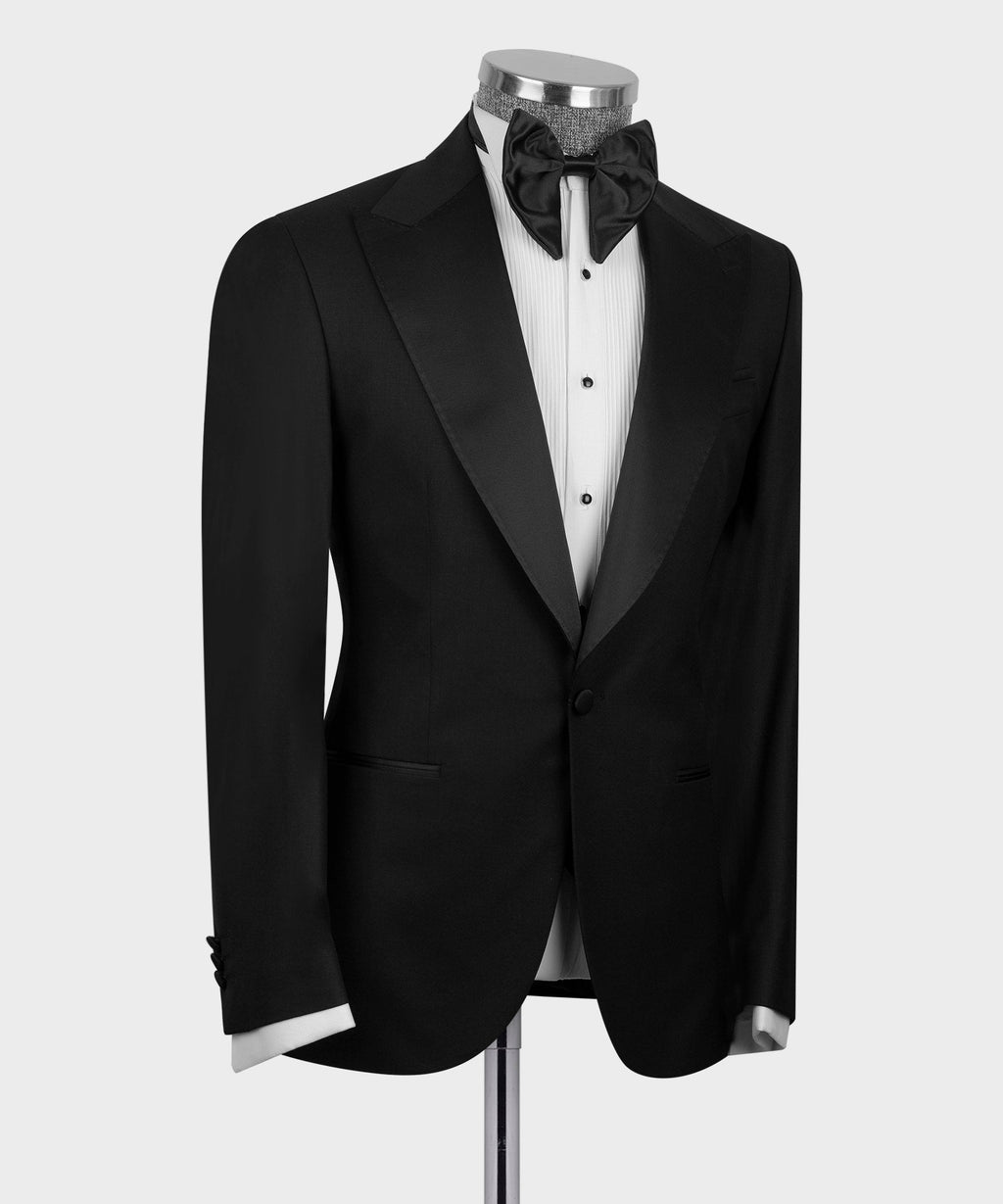 Black three-piece tuxedo suit: peak-lapel jacket, button waistcoat, bow tie