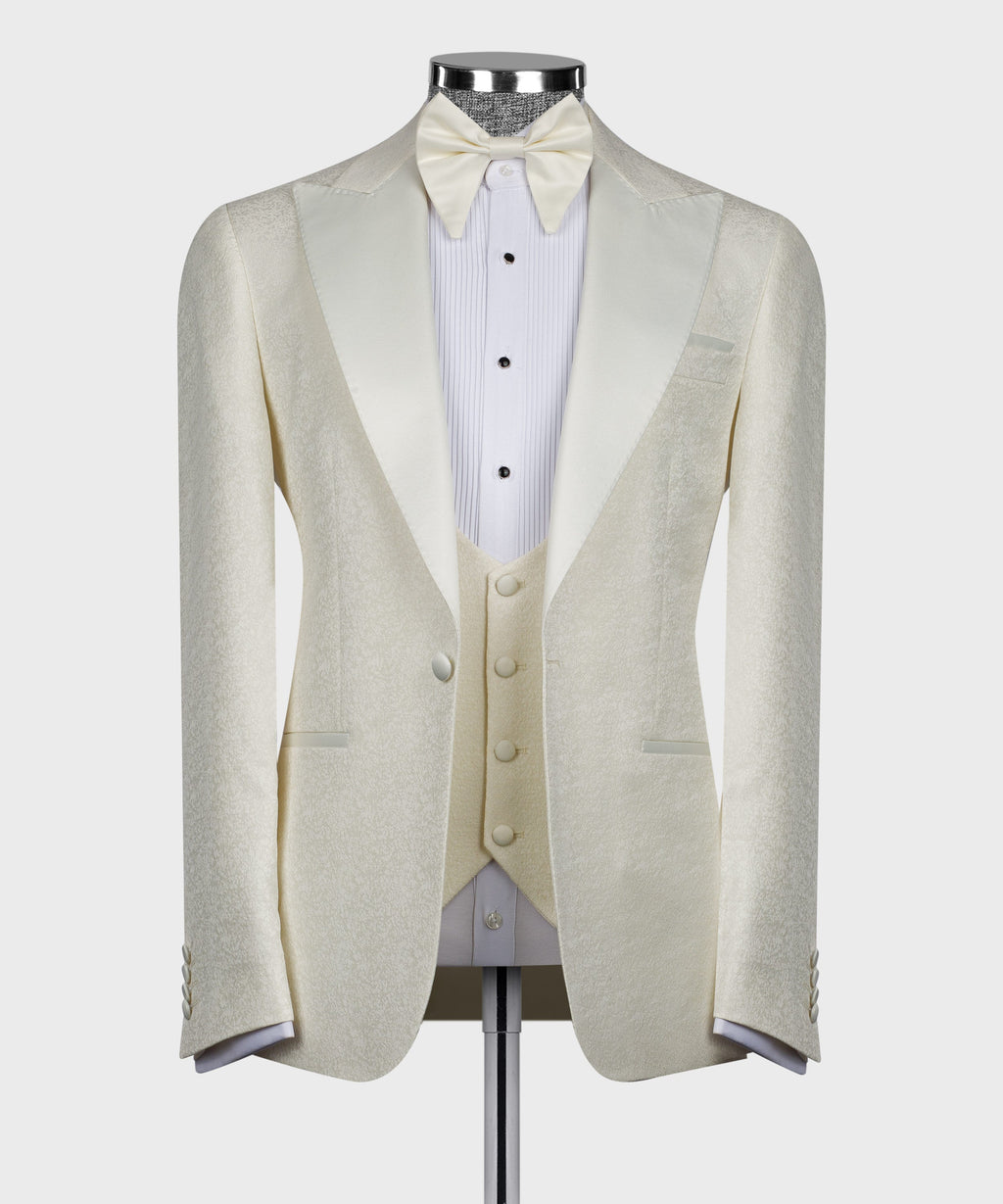 Cream textured tuxedo jacket with satin lapels, white shirt, bow tie and vest