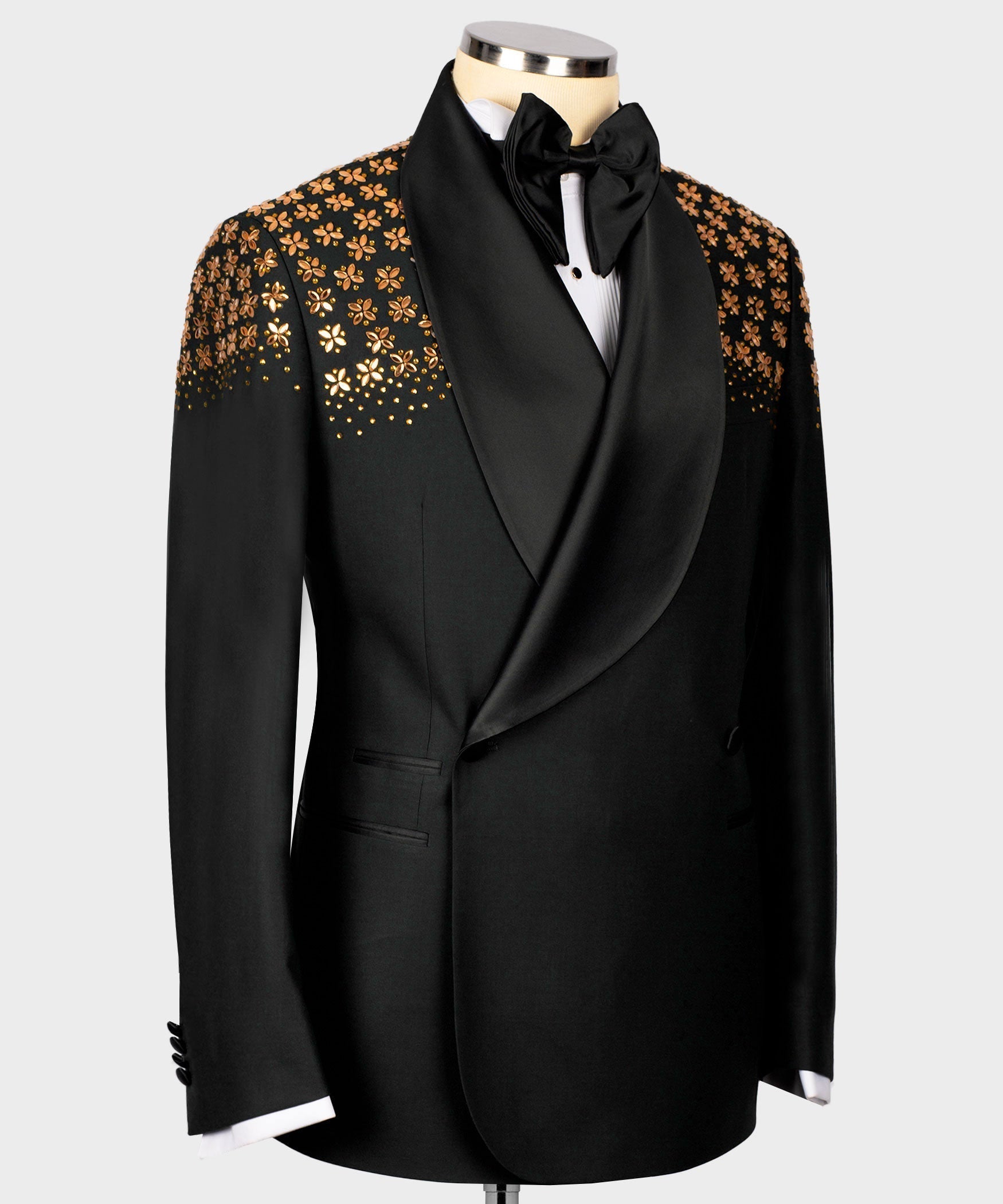 Black tuxedo jacket with gold floral-embellished shoulders and draped satin lapel.