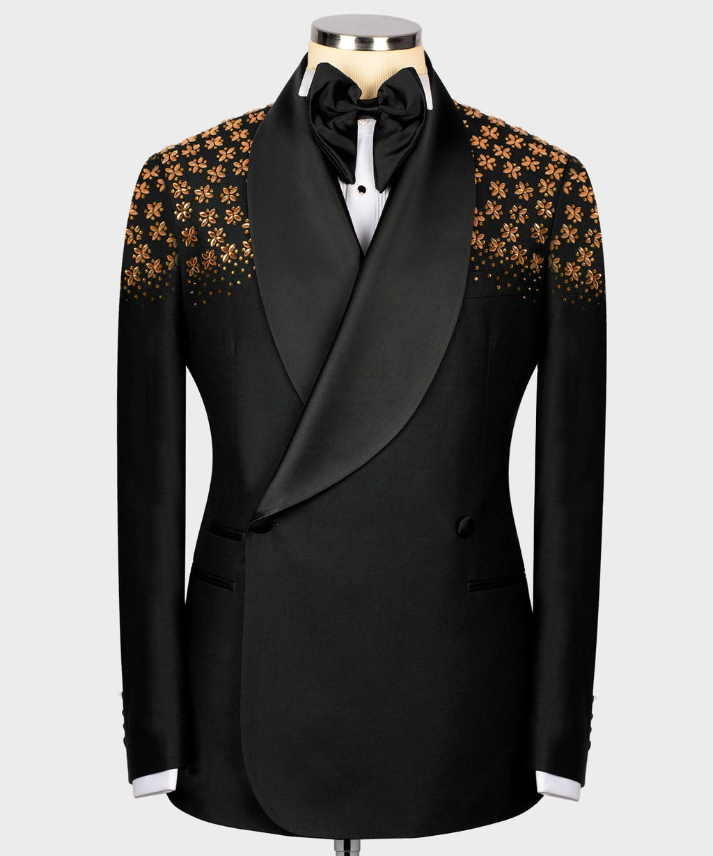 Black tuxedo jacket with gold floral embellished panels and satin bow, on mannequin.