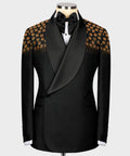 Black tuxedo jacket with gold floral embellished panels and satin bow, on mannequin.