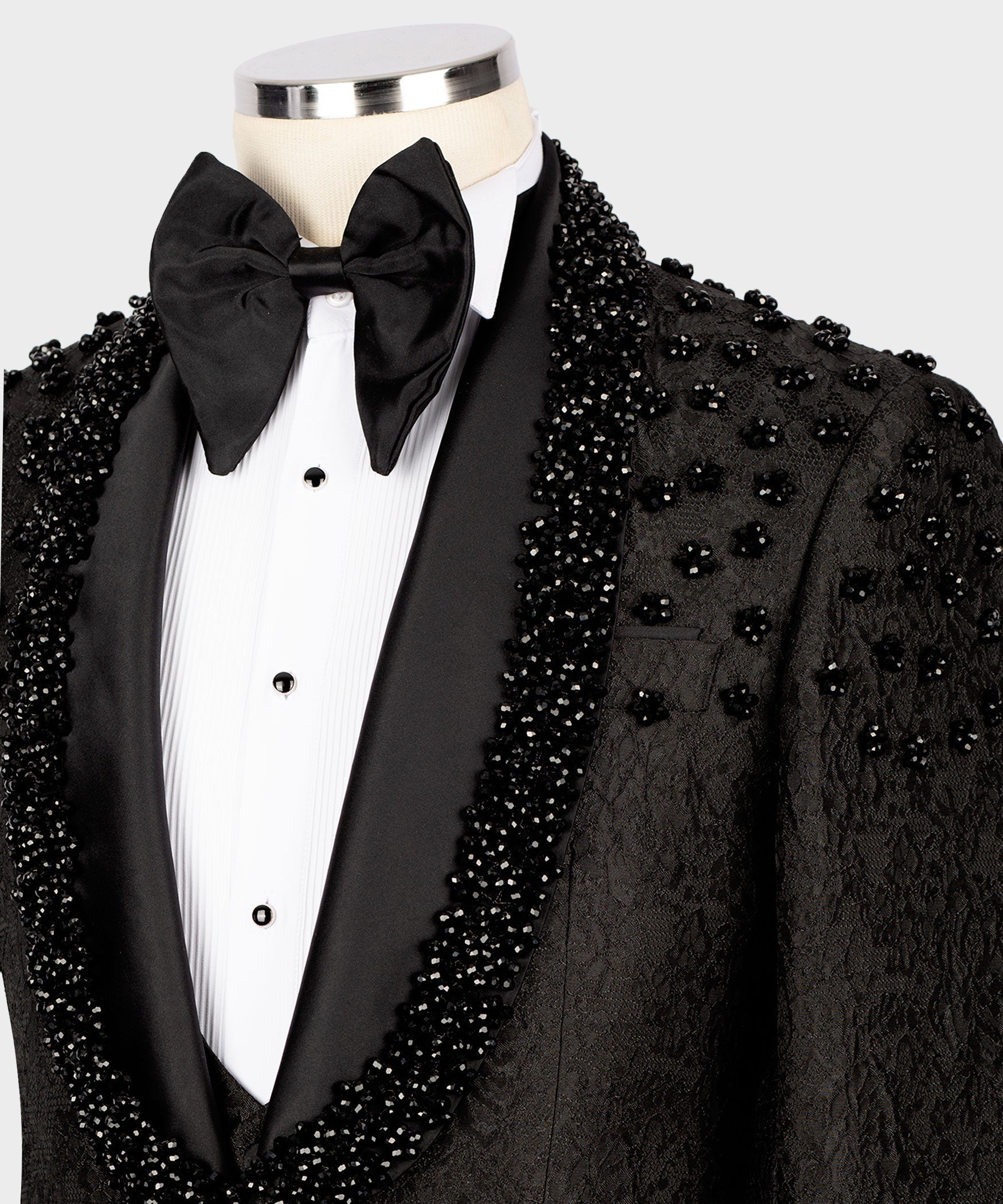 Close-up of black tuxedo lapel with sparkling sequin embroidery and oversized bow