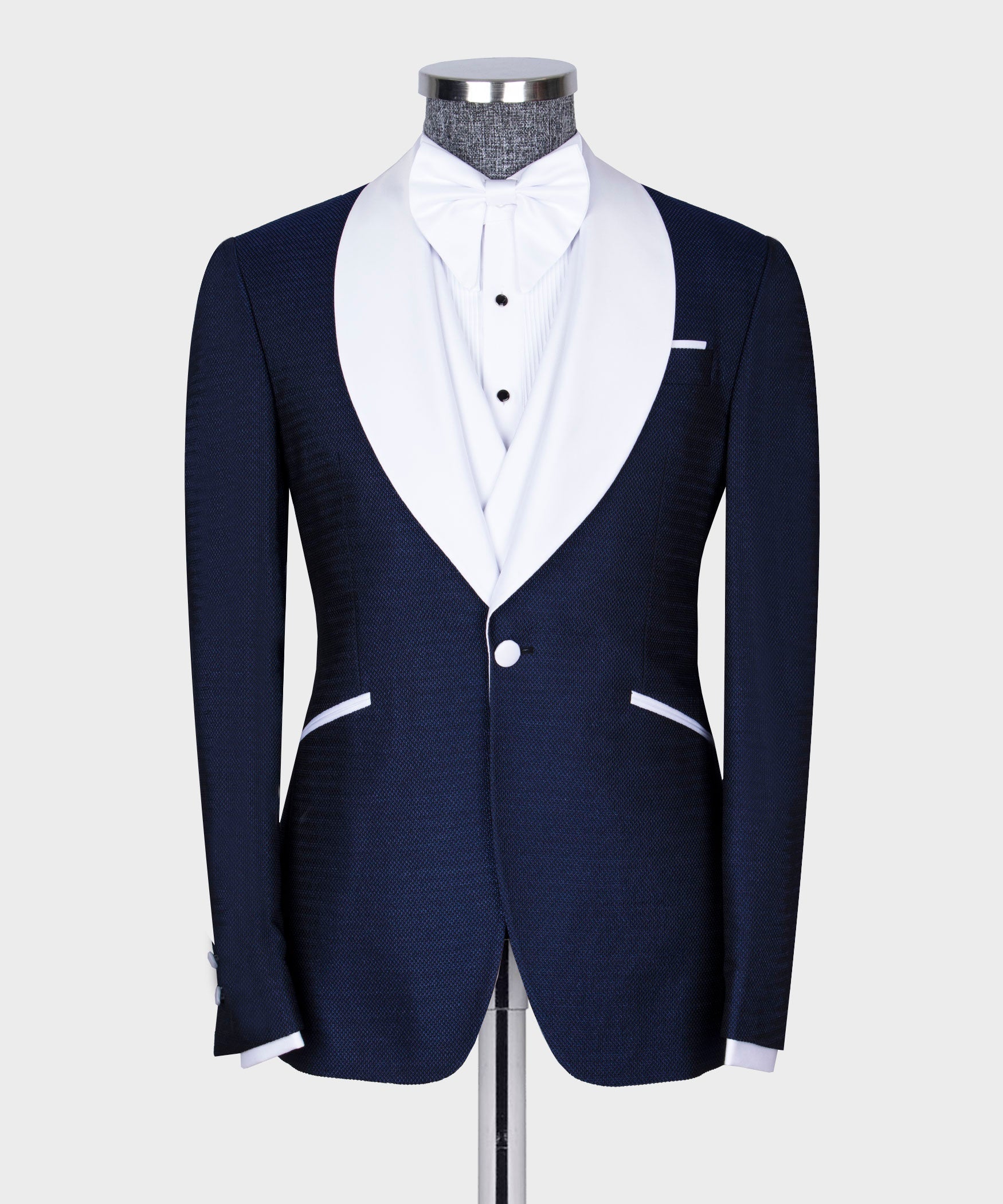 Navy tuxedo jacket with white bow tie and matching waistcoat on dress shirt