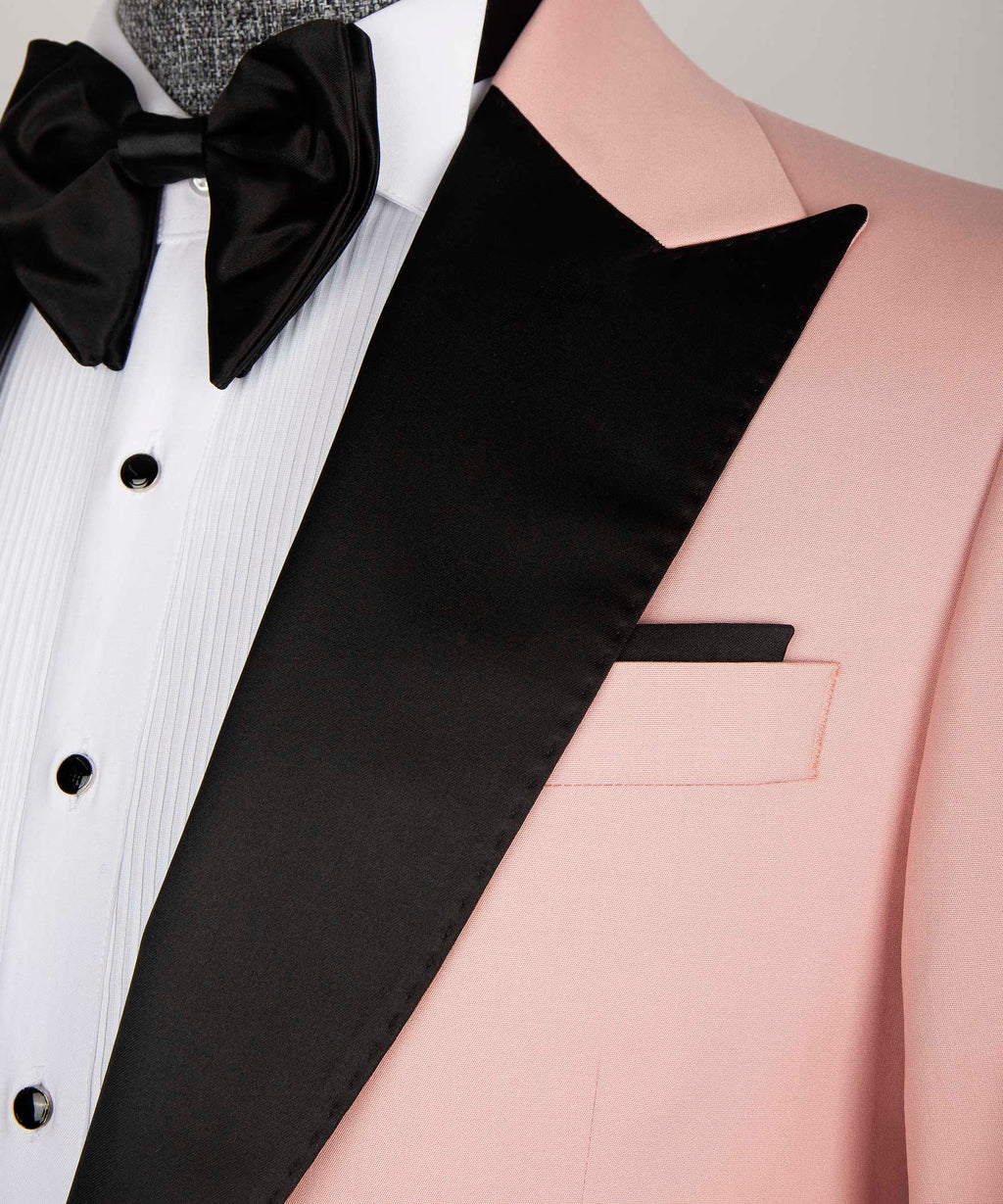 Close-up: black satin lapel edge, pink jacket pocket, and white shirt front