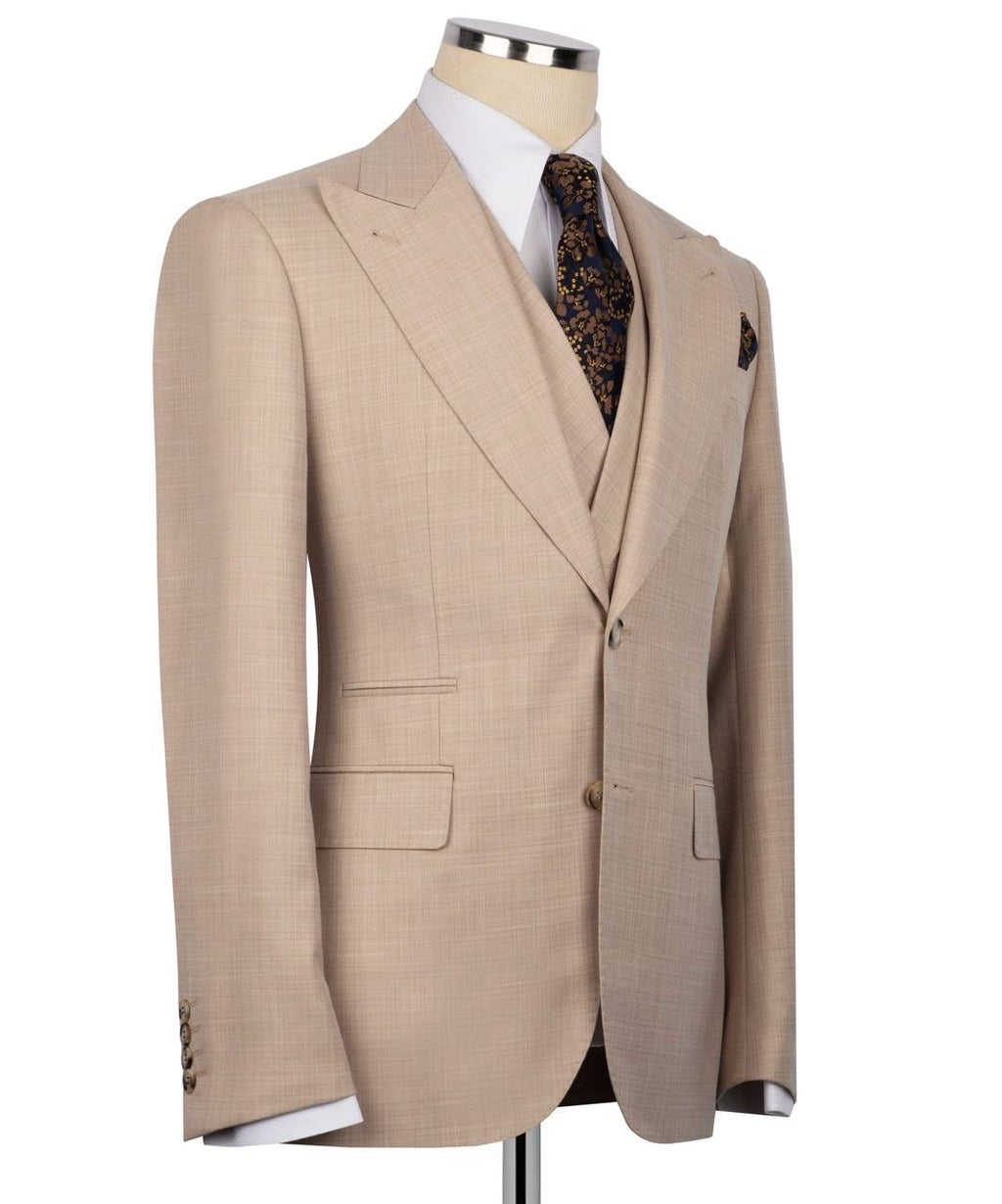 A beige single-breasted suit jacket displayed on a mannequin torso, styled with a white dress shirt, a brown and gold patterned tie, and a matching pocket square 