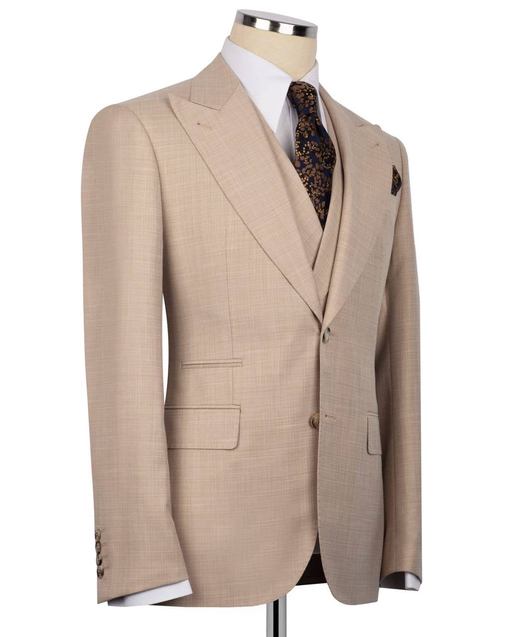 A beige single-breasted suit jacket displayed on a mannequin torso, styled with a white dress shirt, a brown and gold patterned tie, and a matching pocket square 