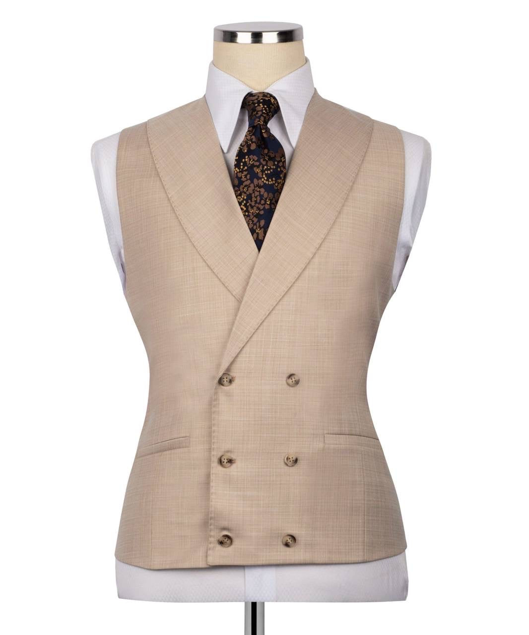 A beige double-breasted suit vest displayed on a mannequin torso, styled with a white dress shirt and a dark patterned tie 
