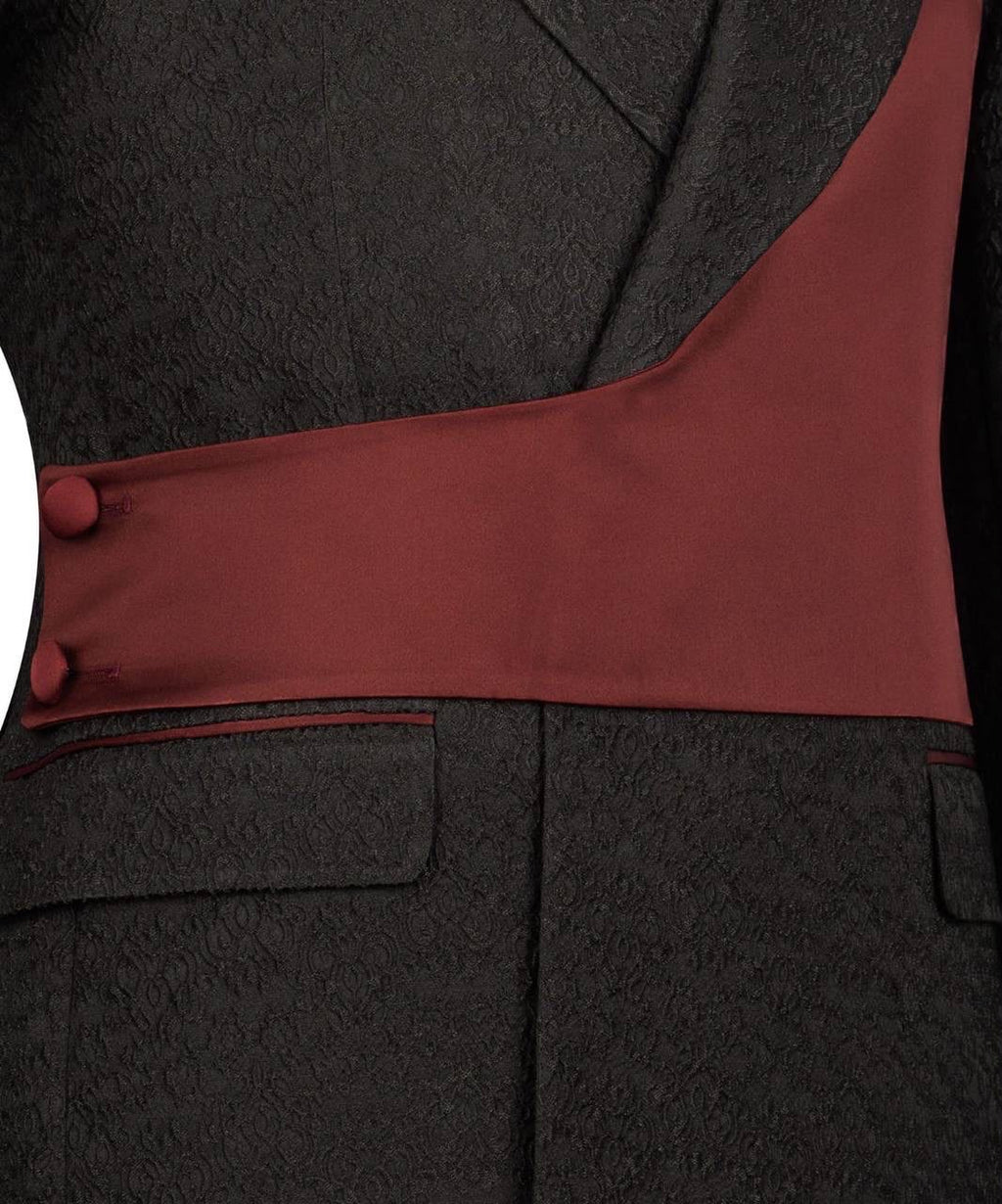 Close-up of a dark gray suit with a red lining and buttons.