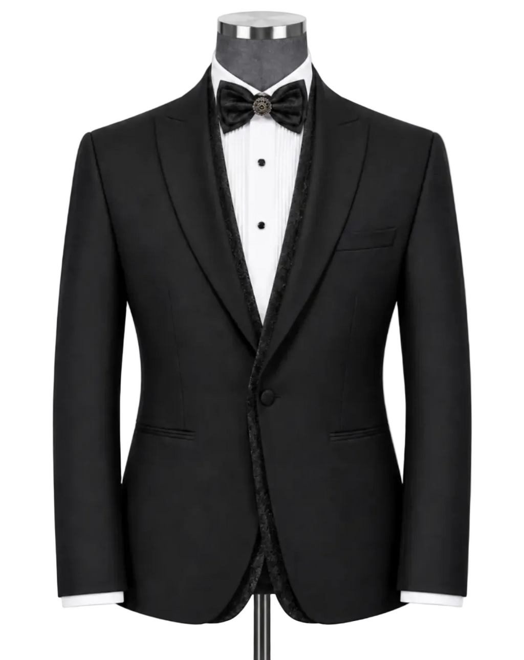A black tuxedo jacket displayed on a mannequin torso with a white dress shirt, black bow tie, and black patterned inner shawl collar, against a light gray studio background.