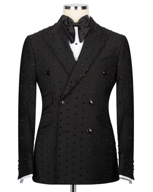 A black double-breasted tuxedo jacket embellished with small silver studs, displayed on a mannequin with a black bow tie and white shirt.